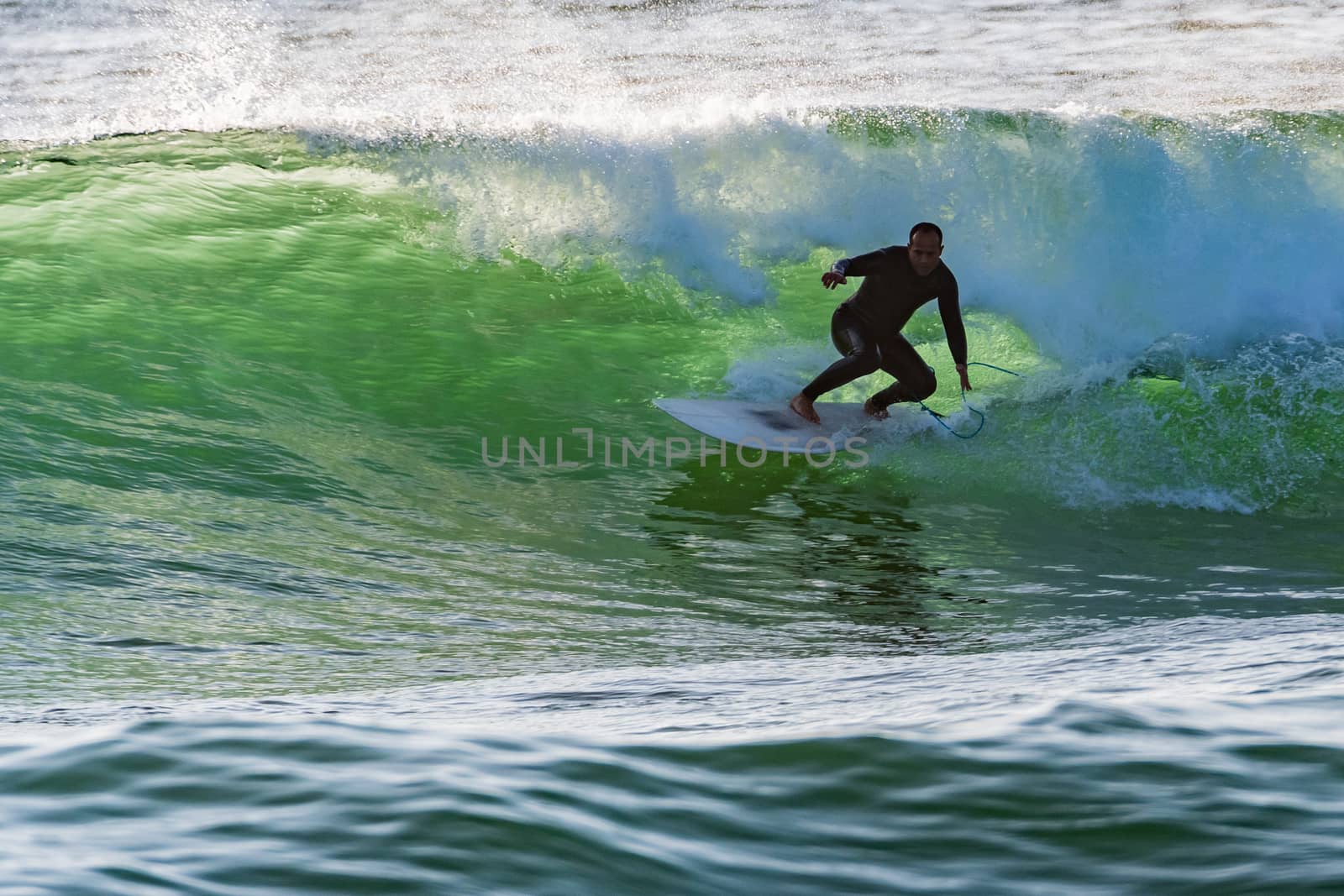 Long boarder surfing the waves at sunset in Portugal.