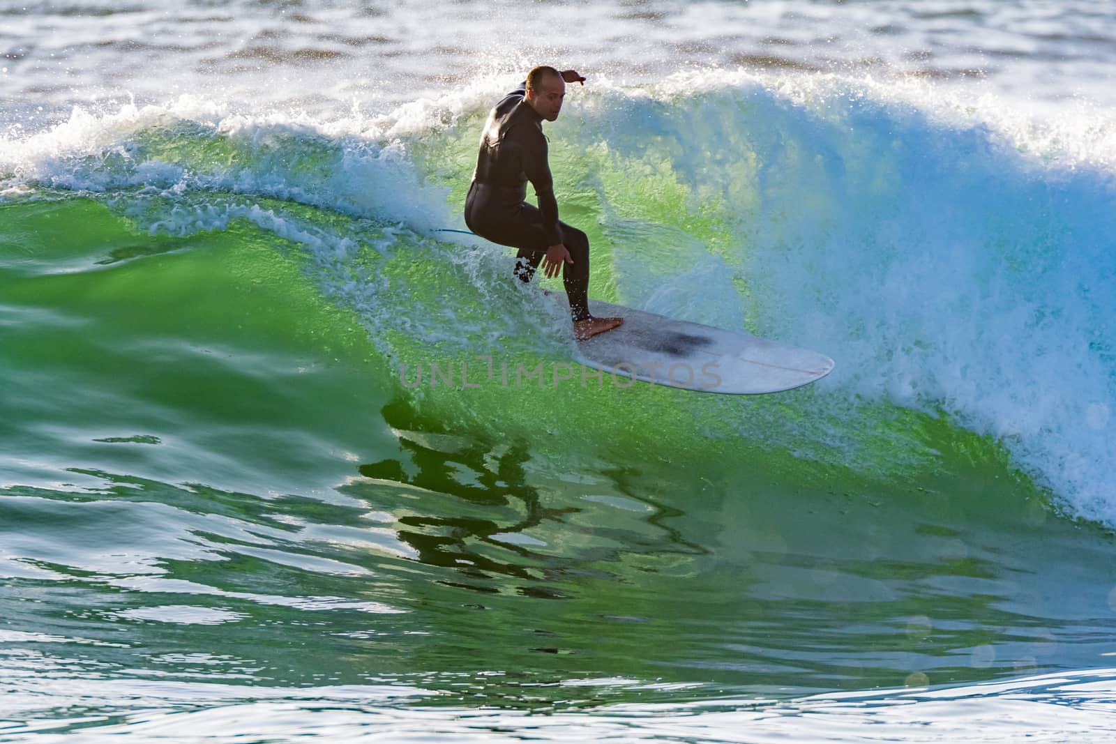 Long boarder surfing the waves at sunset in Portugal.