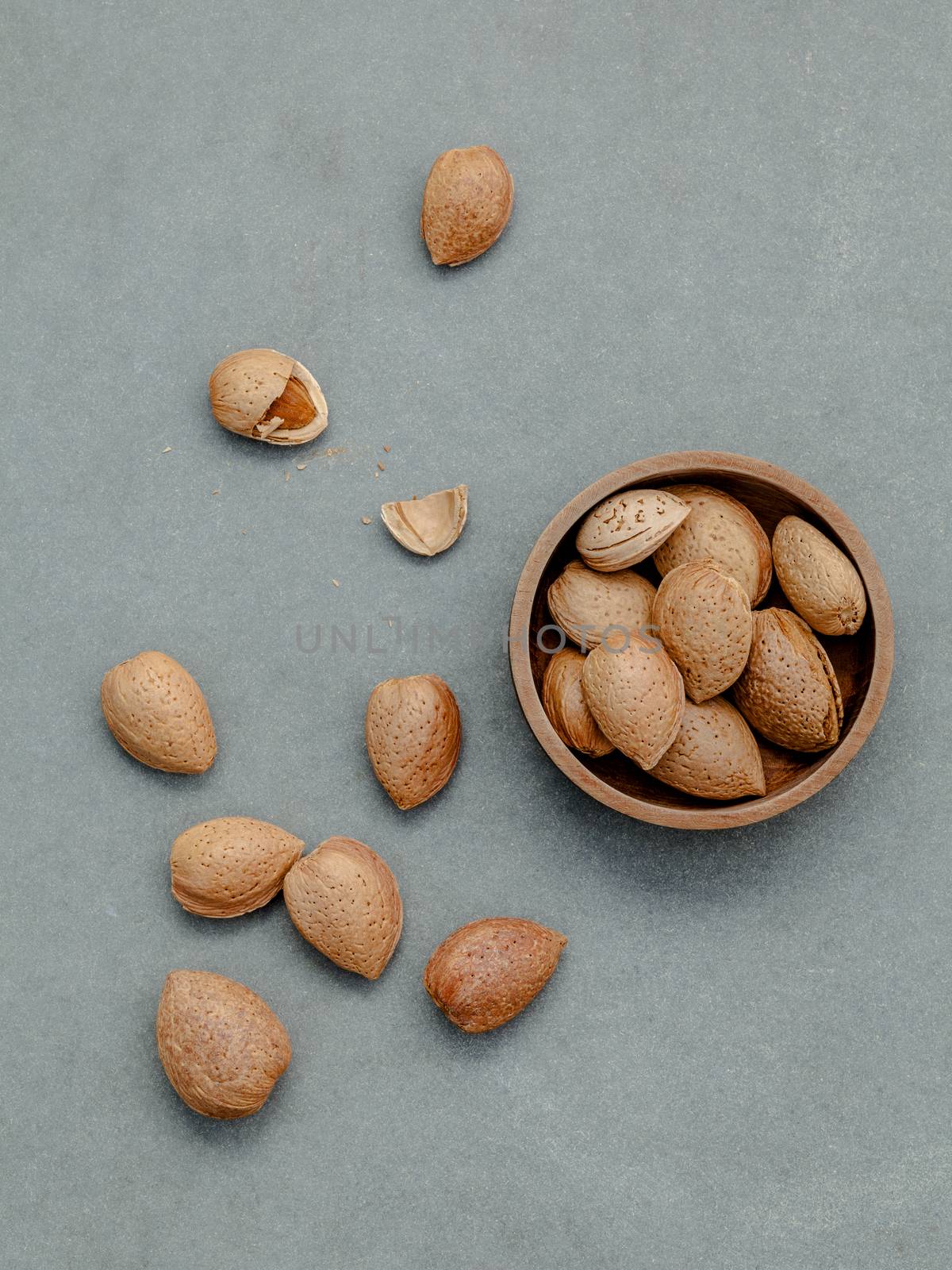 Almonds kernels and whole almonds on concrete background. Whole  by kerdkanno