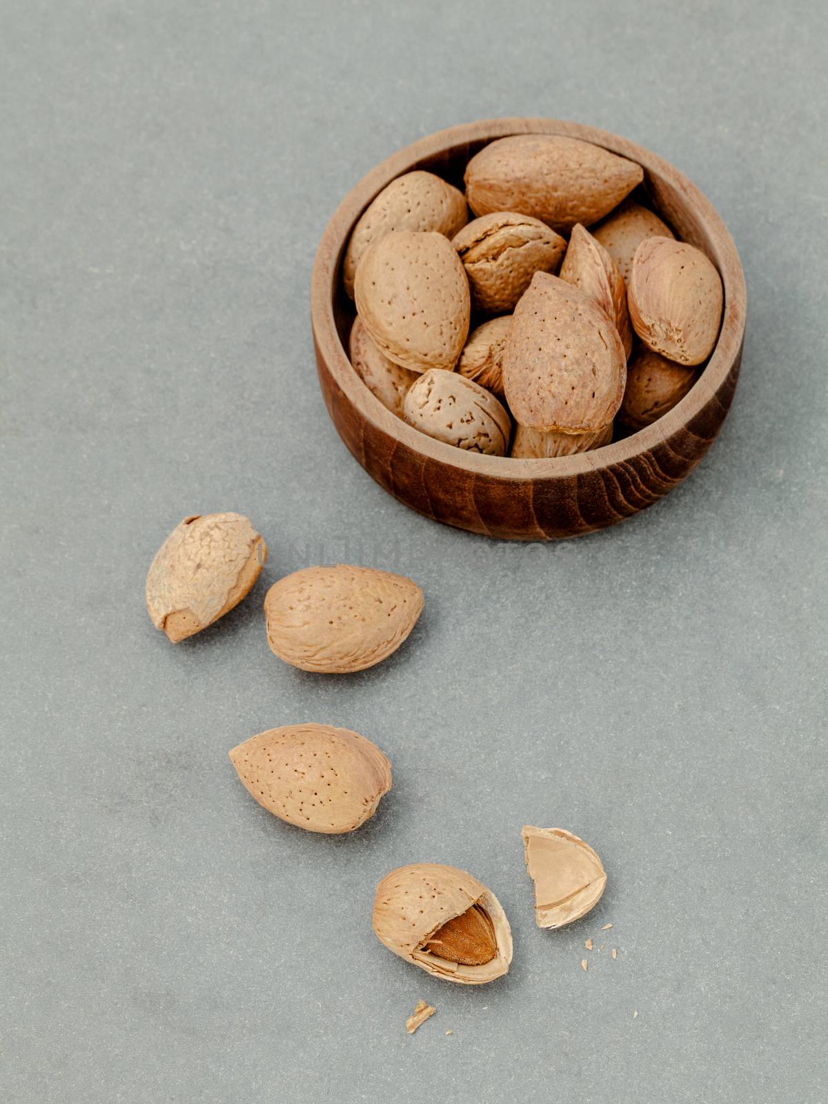 Almonds kernels and whole almonds on concrete background. Whole and chopped almond on concrete background. almond kernels and nutcracker. Selective focus depth of field.