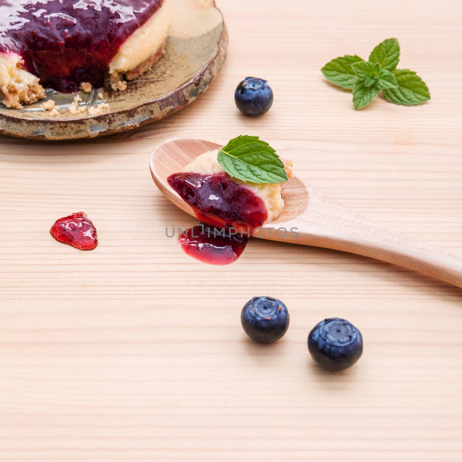 Blueberry cheesecake with fresh mint leaves on wooden background by kerdkanno