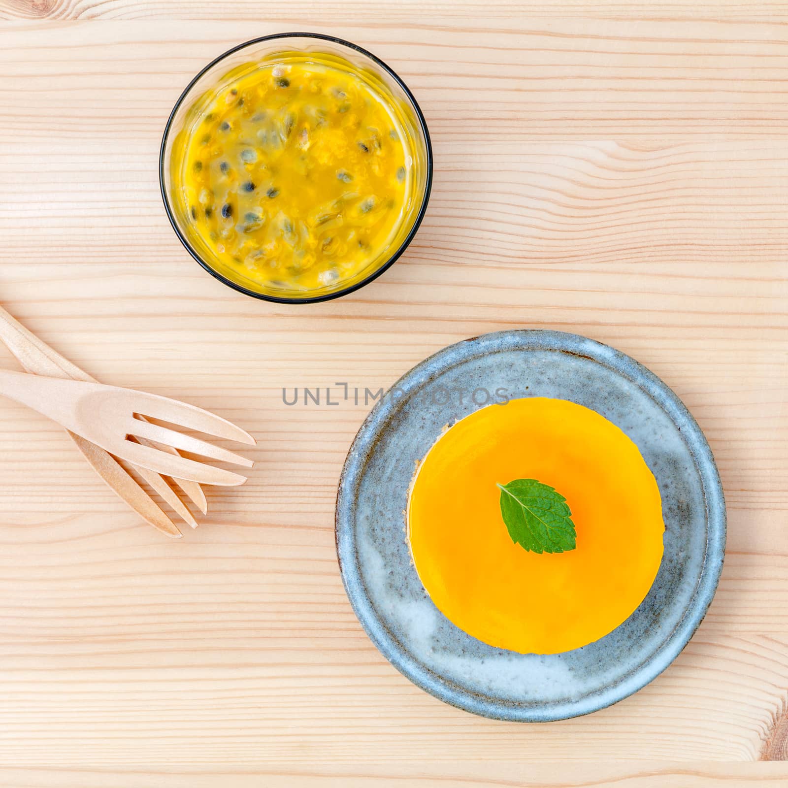 Passion fruit cheesecake with fresh mint leaves on wooden background. Passion fruit cheesecake setup with Passion fruit juice and fresh Passion fruit .Selective focus depth of field.