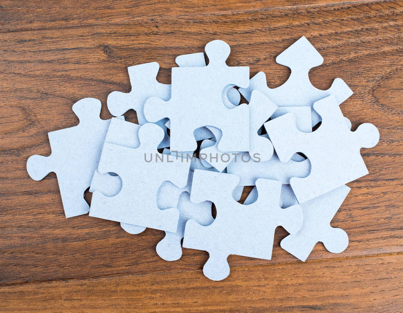 Pile of puzzle pieces on table. by cherezoff