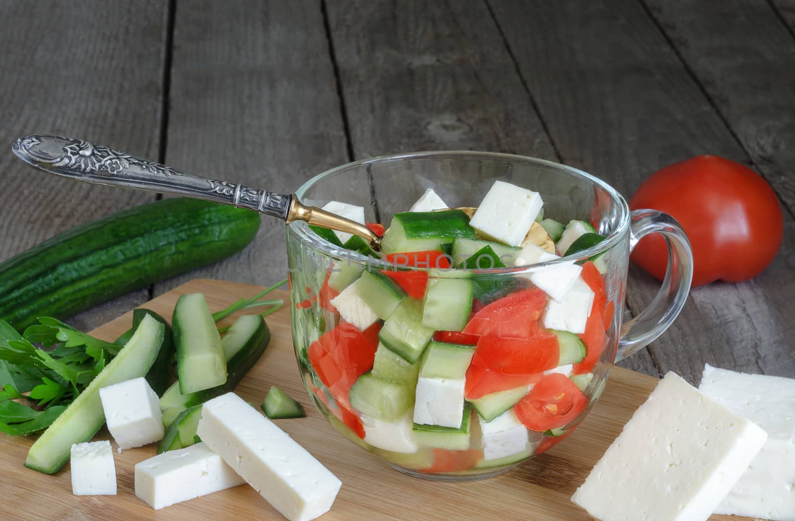 Salad with vegetables and cheese in glass Cup, ingredients,silver spoon