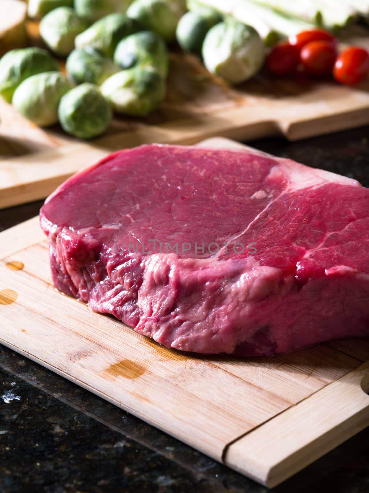 close up view of fresh piece of meat with some vegetables on the back