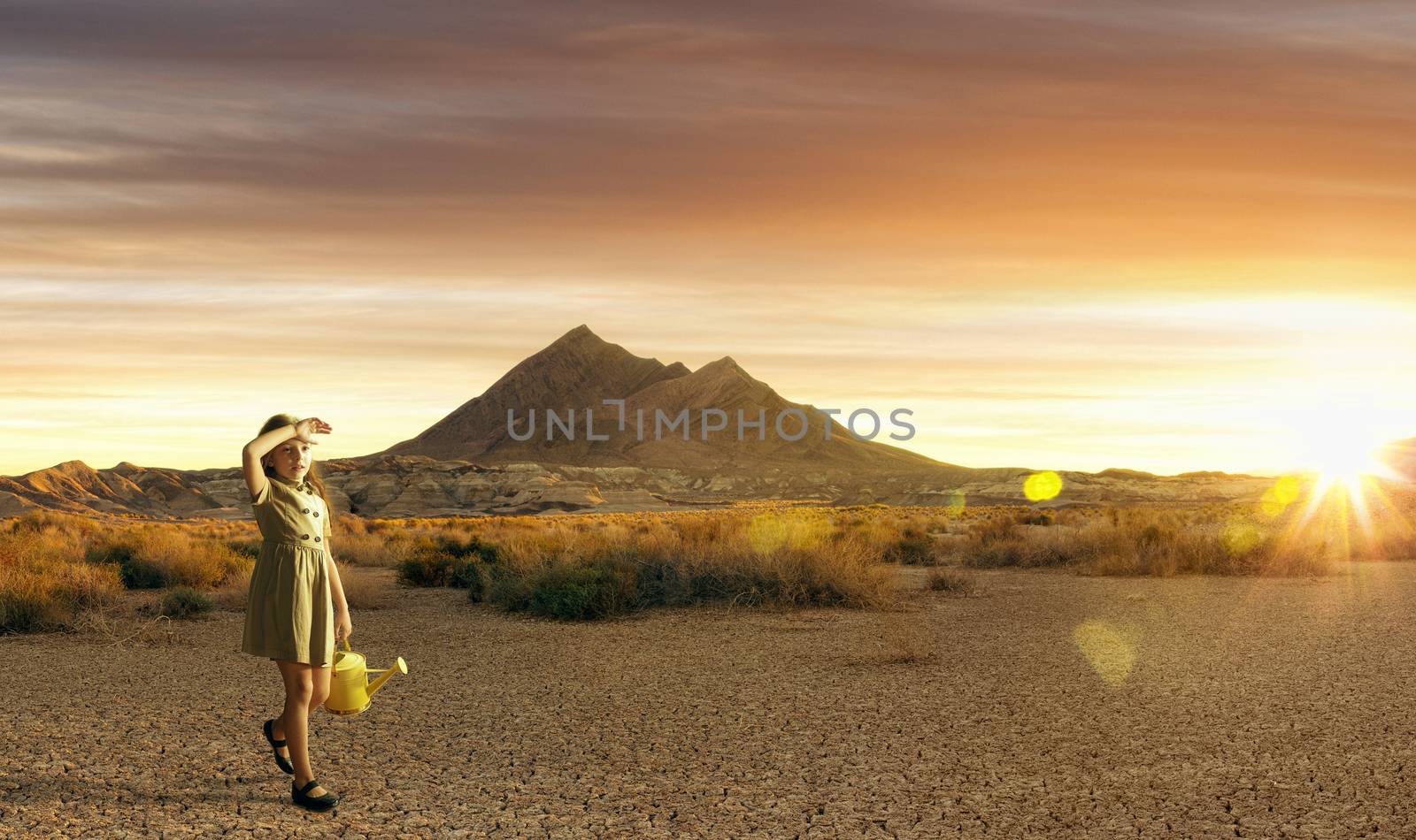 Portrait of little white girl walking through the desert during sunset