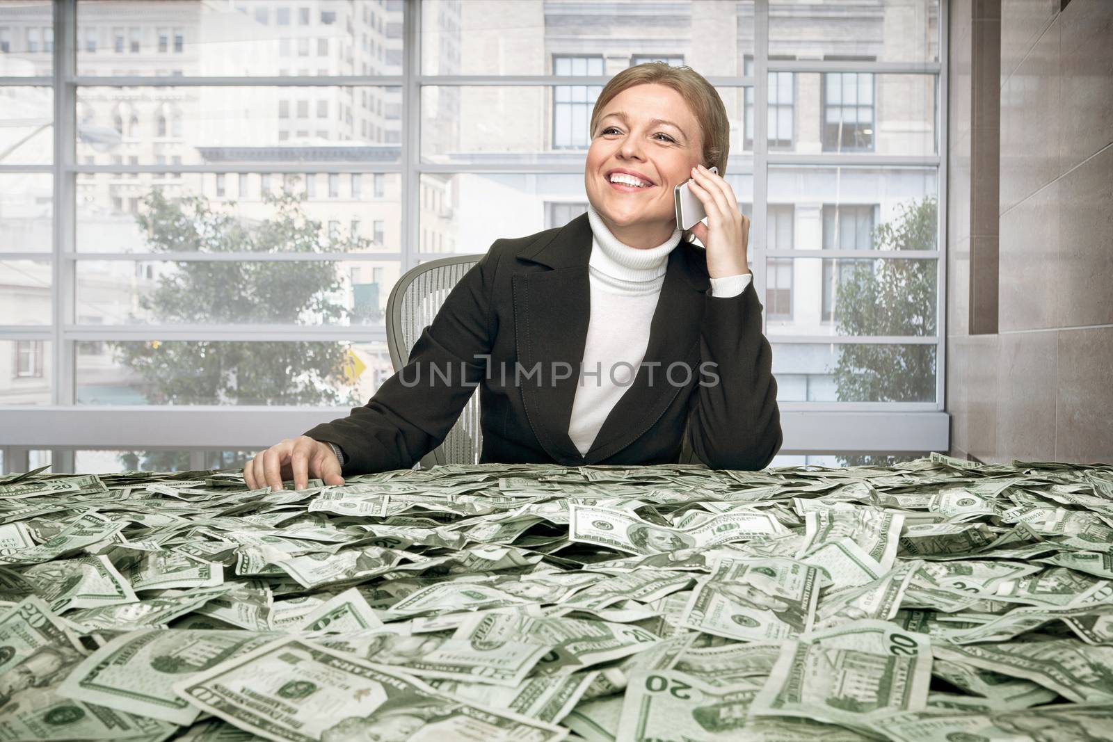 portrait of young woman sitting behind the table full of cash