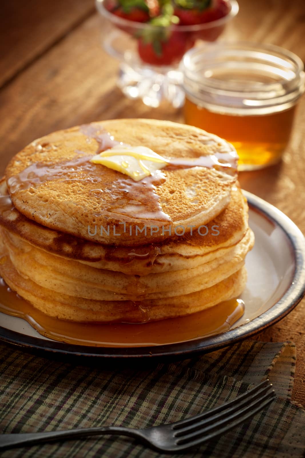 close up view of nice yummy pancakes with honey on table