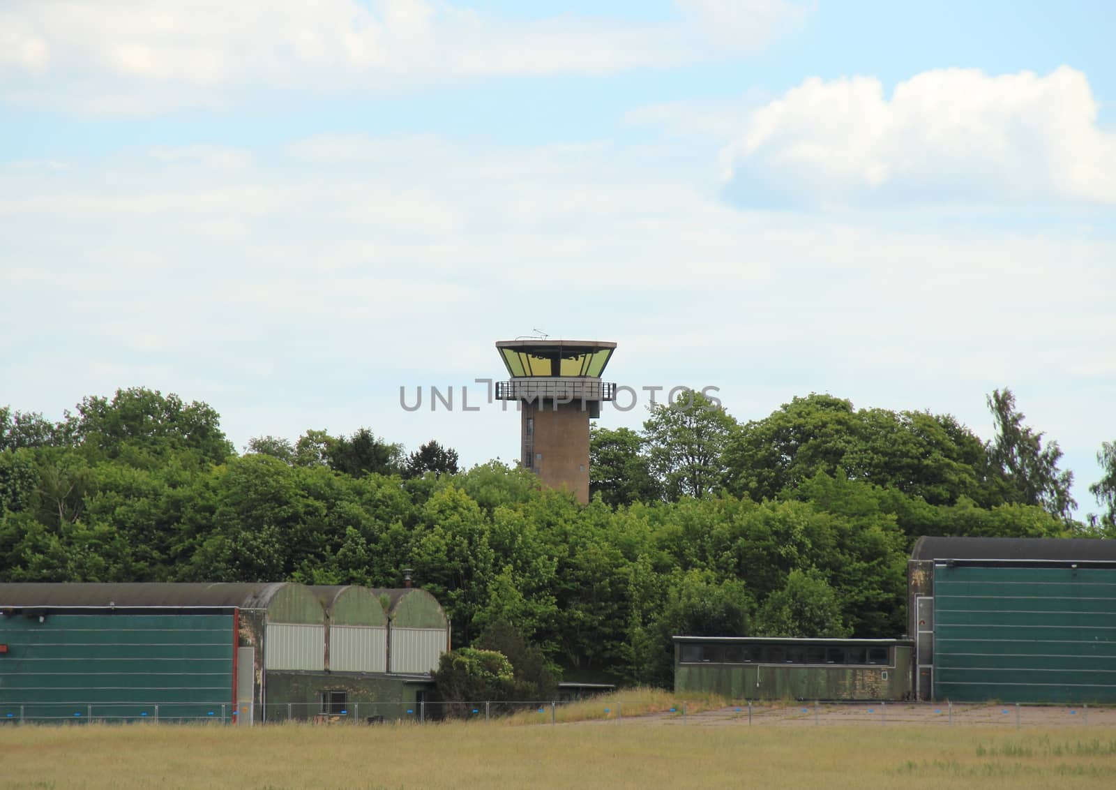 Airfield control tower hidden in forest with clouds