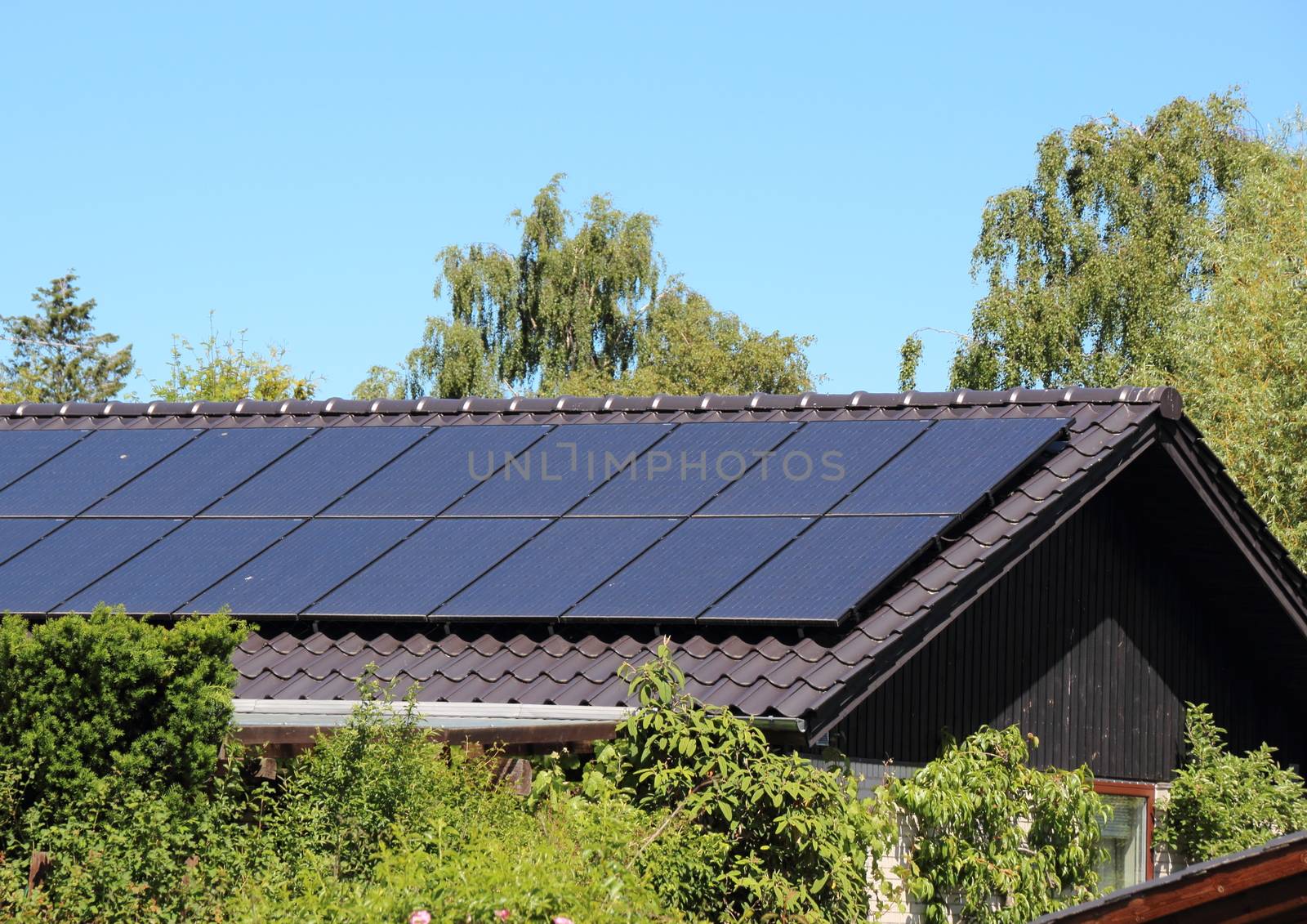 Solar collector on house roof with blue sky