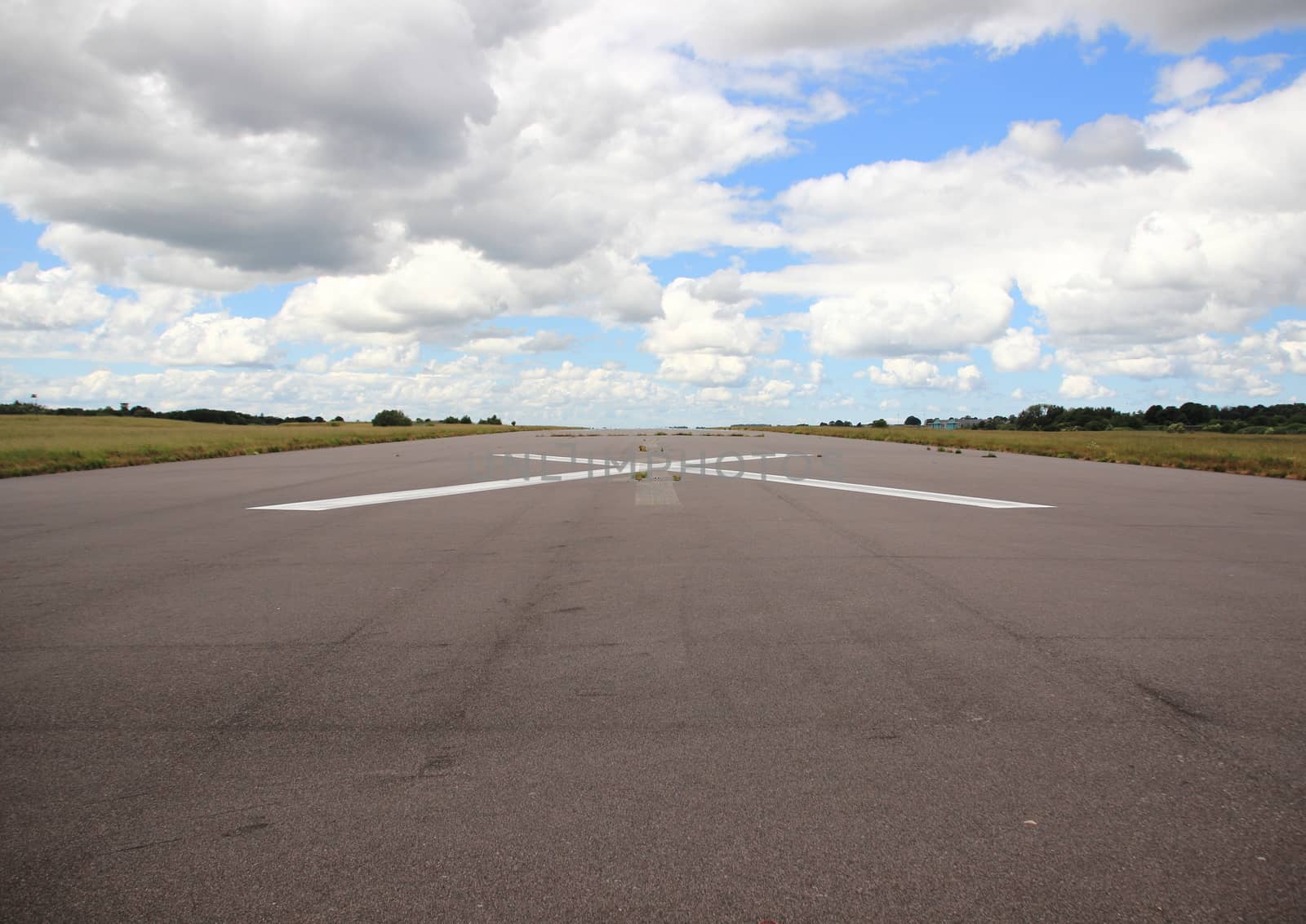 Empty airplane runway with white cross