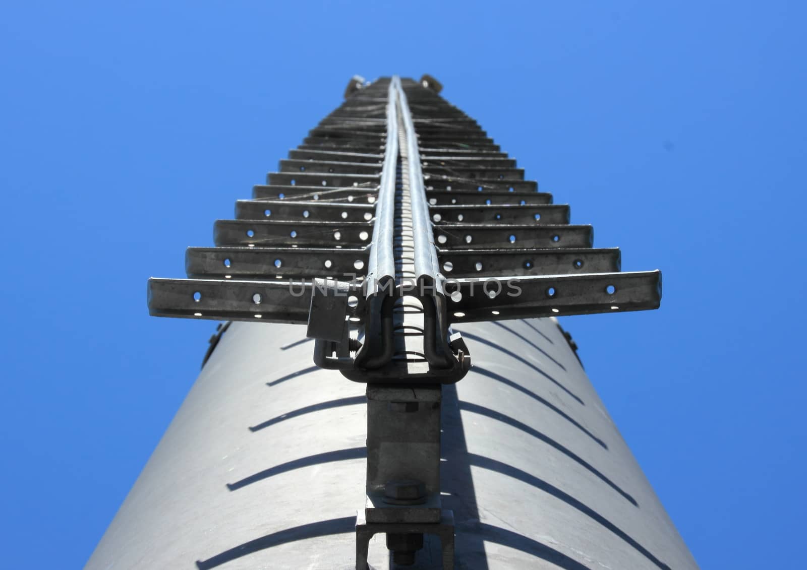 Metal ladder on chimney against blue sky