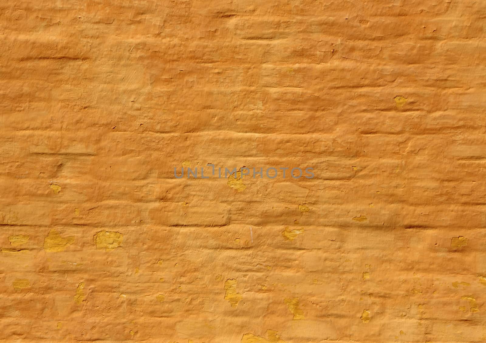 Old ochre yellow painted brick wall background