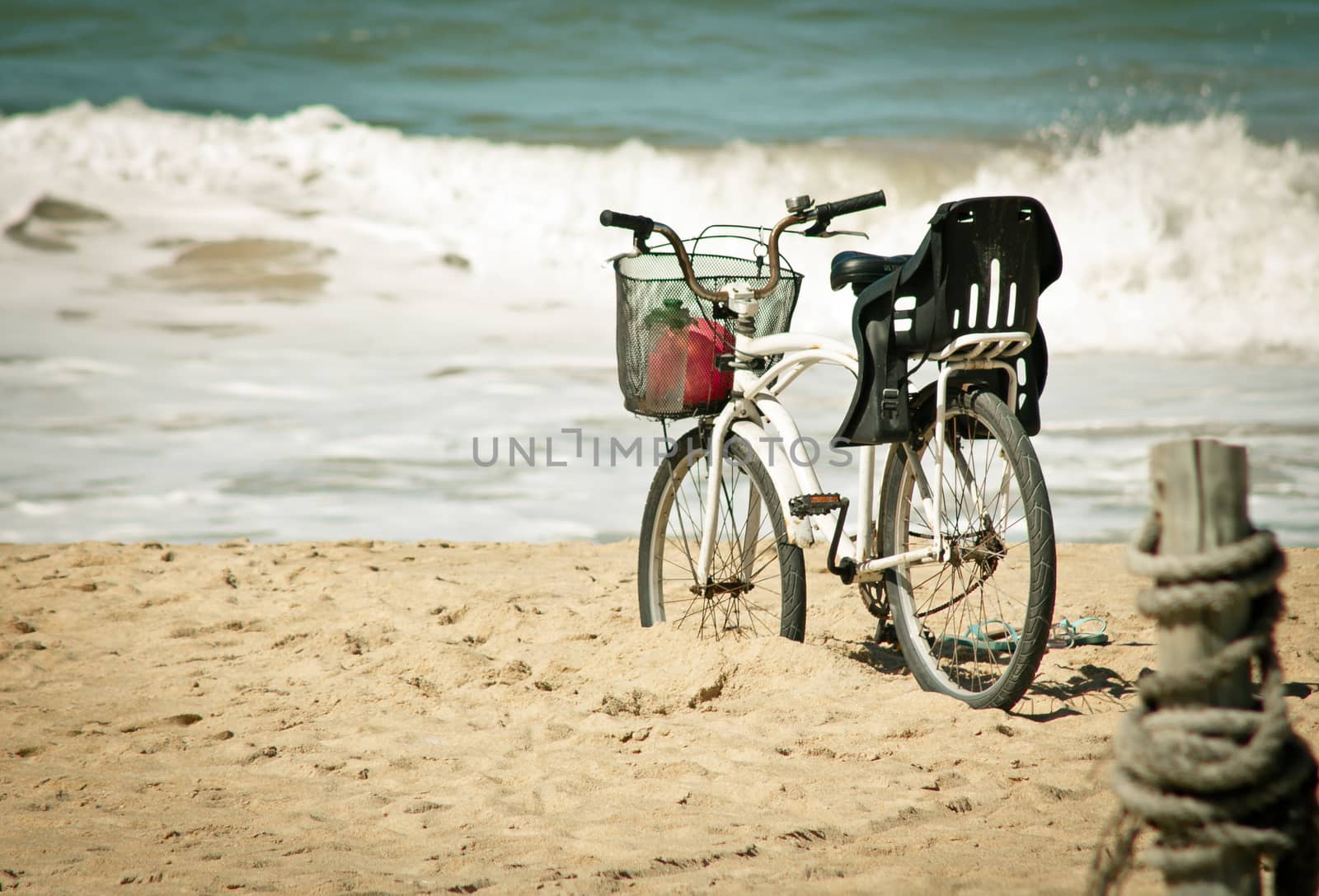 Bicycle on the sand with view of teh sea and waves