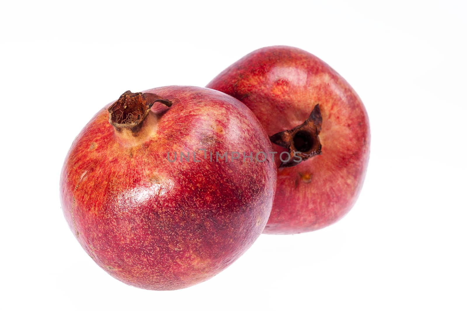 two red fruits of  pomegranate  isolated on white background