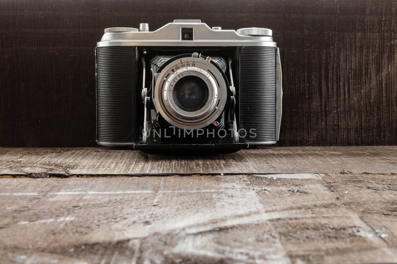Full vintage bellows camera on a wood background