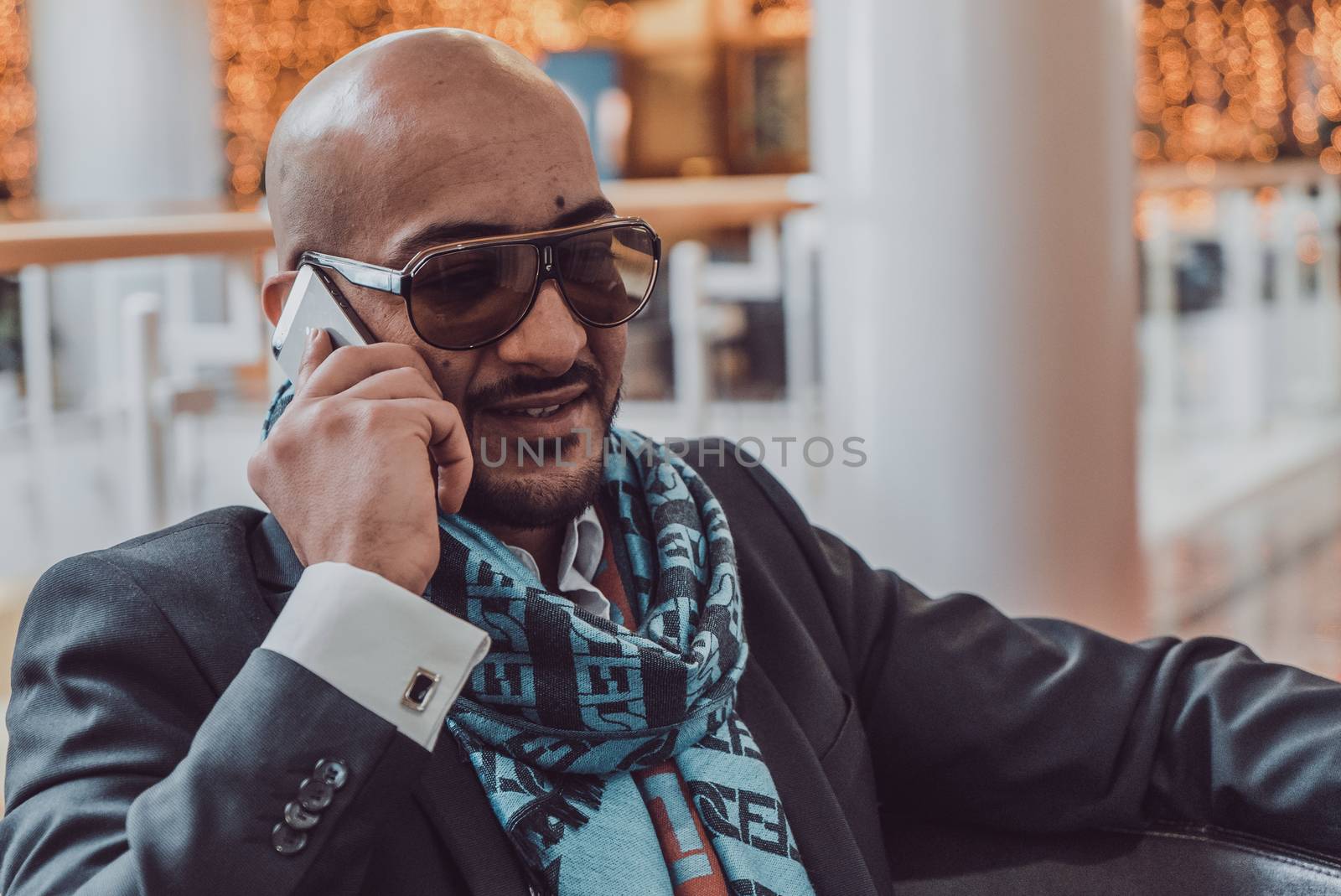 Arab businessman talking on mobile phone at a shopping center