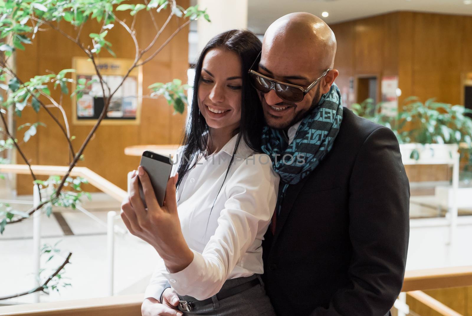 Arab businessman and girl making selfie in the shopping center