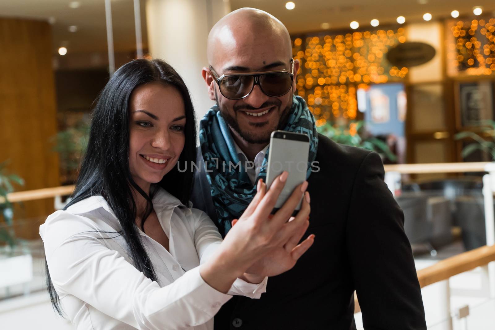 Arab businessman and girl making selfie in the shopping center