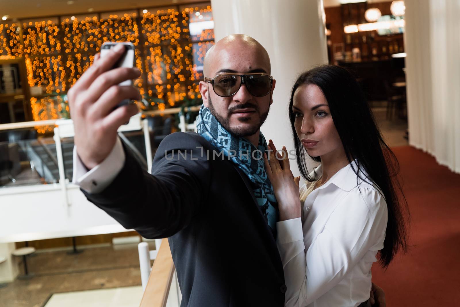 Arab businessman and girl making selfie in the shopping center