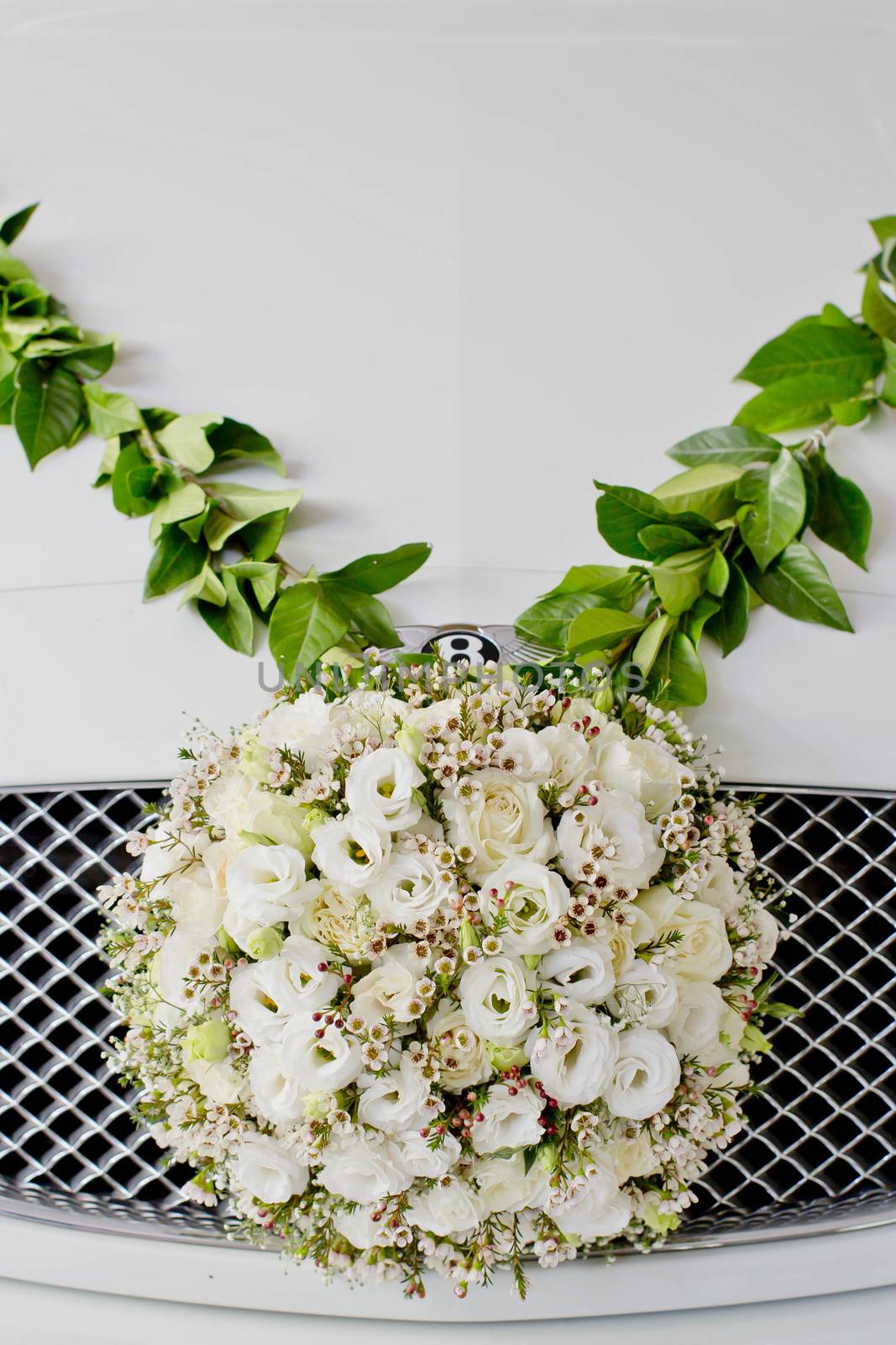 Flower arrangement in ball shape decorate front of front grill of car. The Wedding Flower.