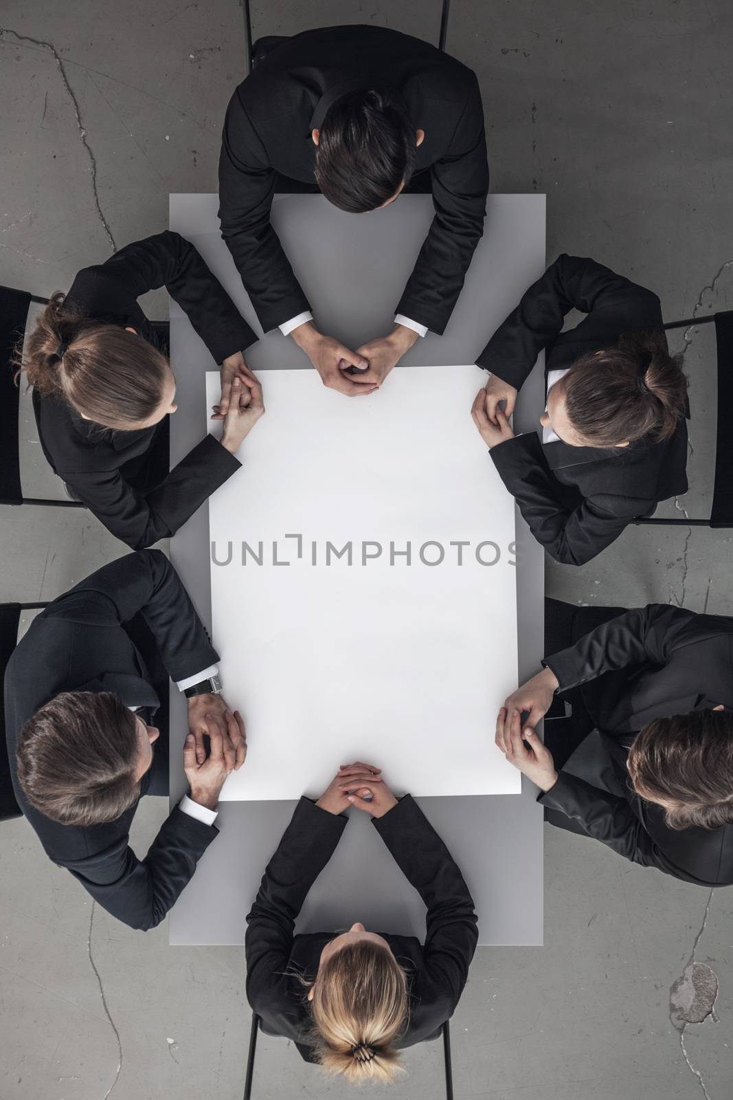 Business people at meeting around the table with blank paper