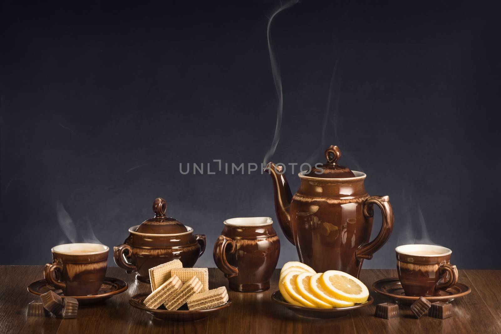 Hot coffee in cups and a dessert on a table against a dark background