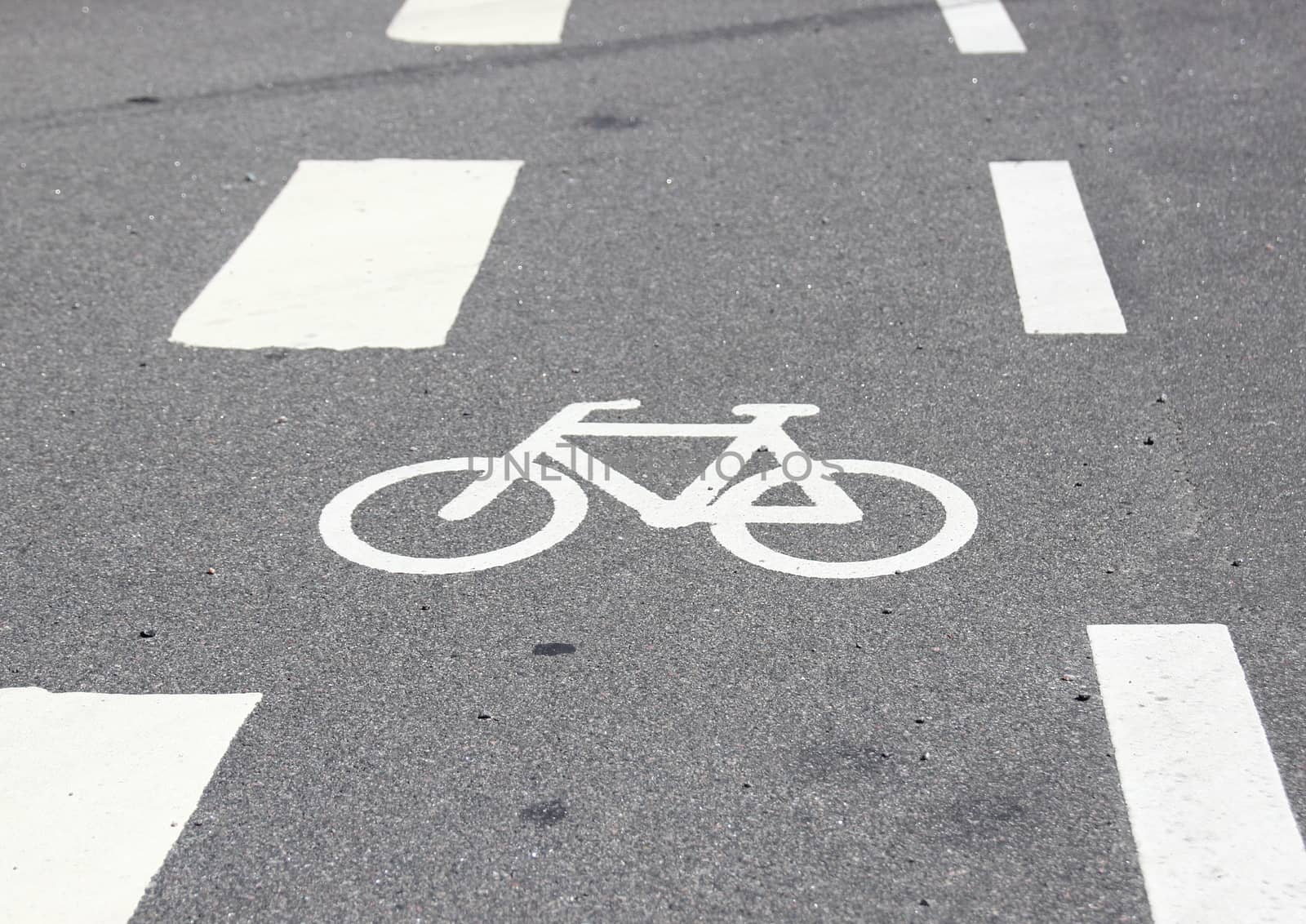 Horizontal bicycle sign on asphalt with white stripes