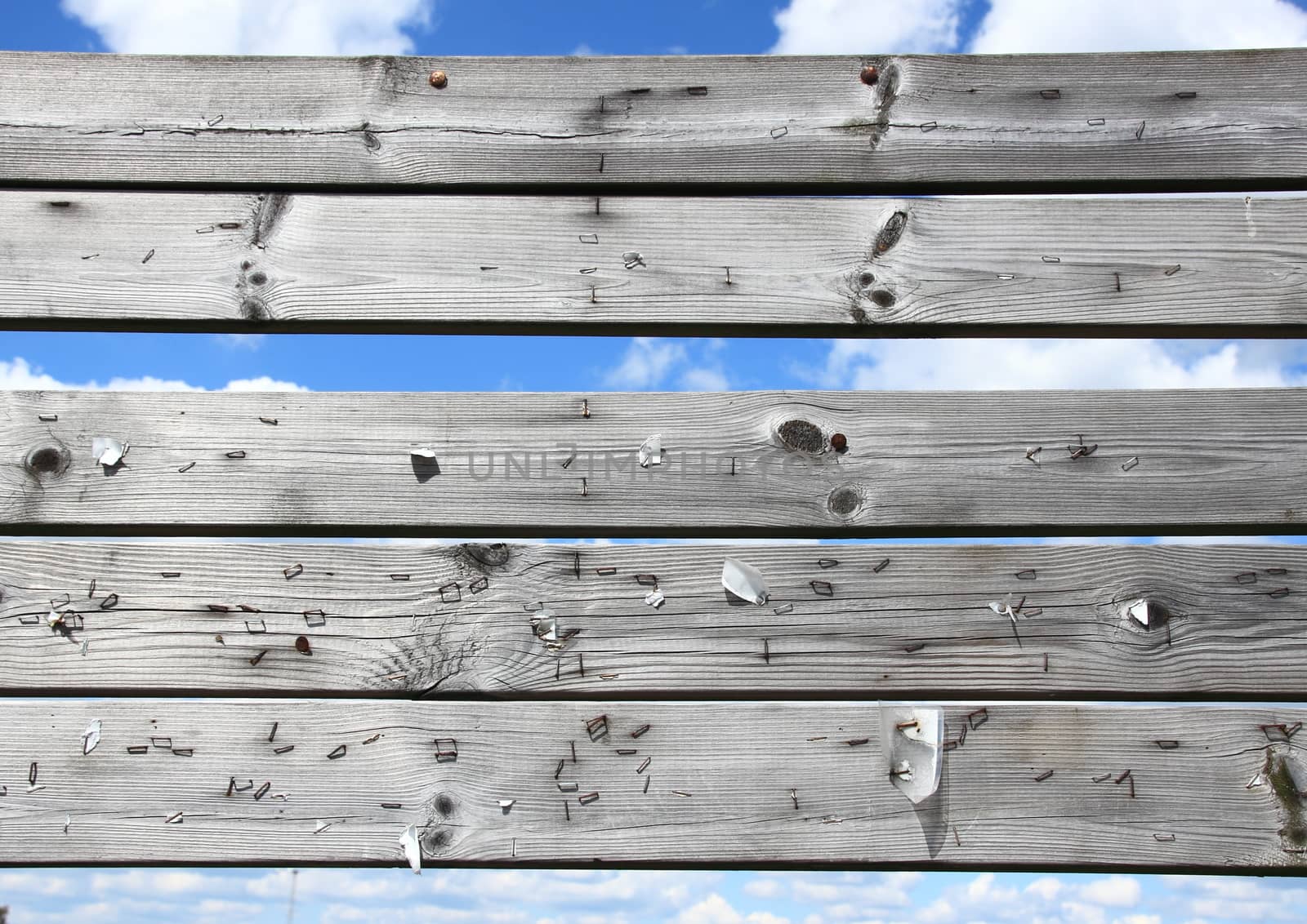 Dashboard of worn planks with rusty staples