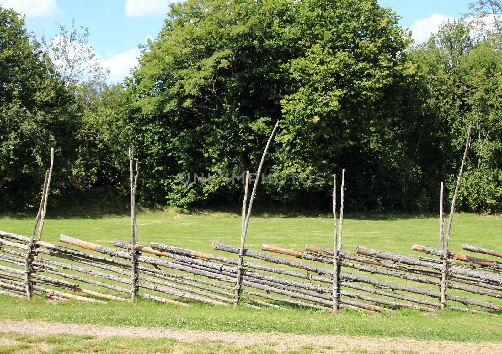 Rural simple wooden fence at hay field