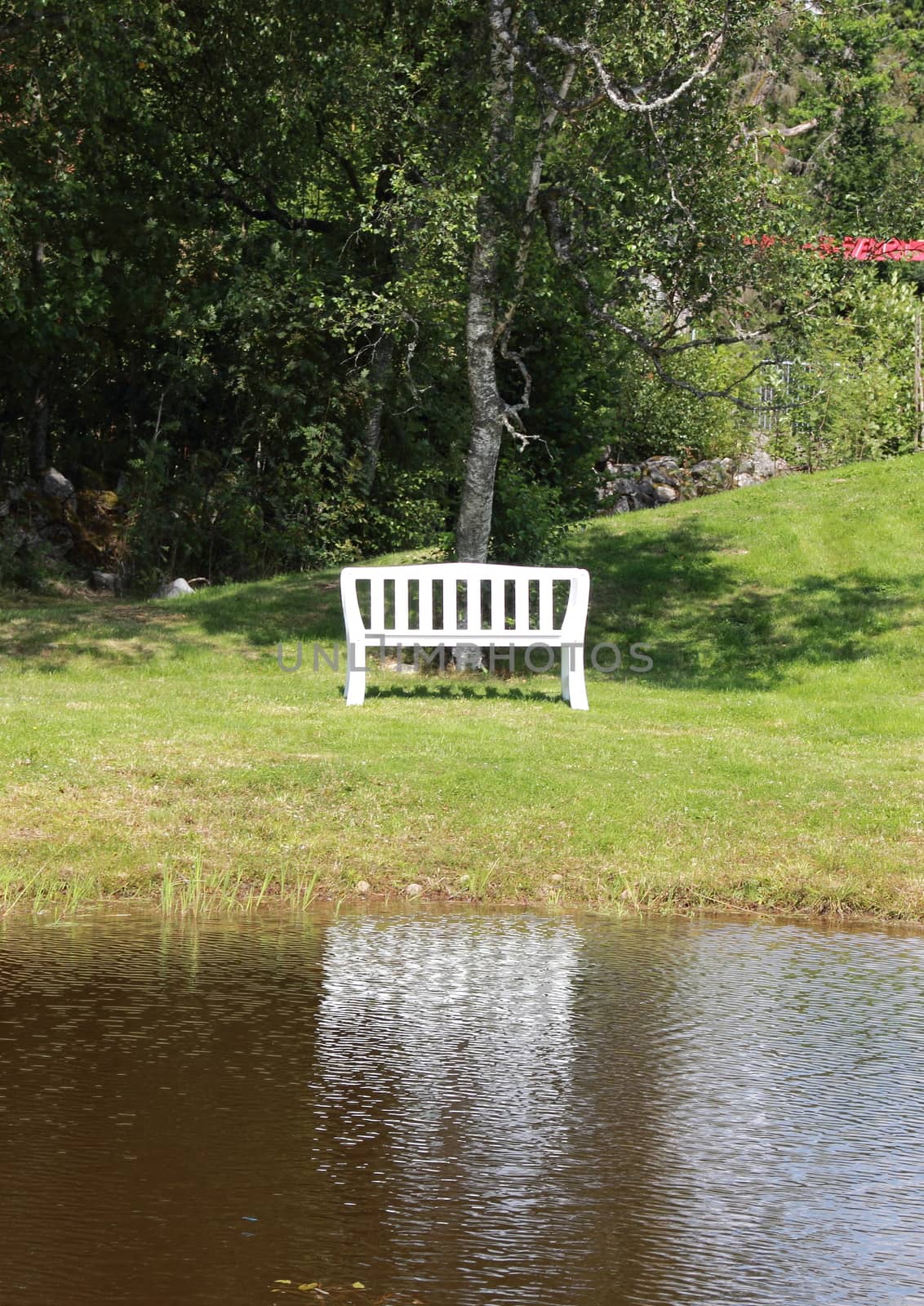 White bench at lake with water reflection by HoleInTheBox