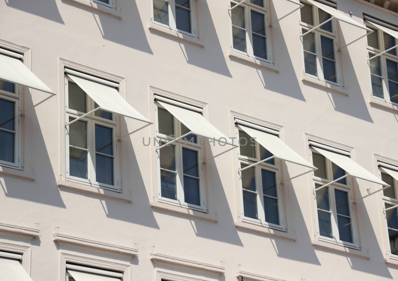 Closeup perspective on grey building with  white awning by HoleInTheBox