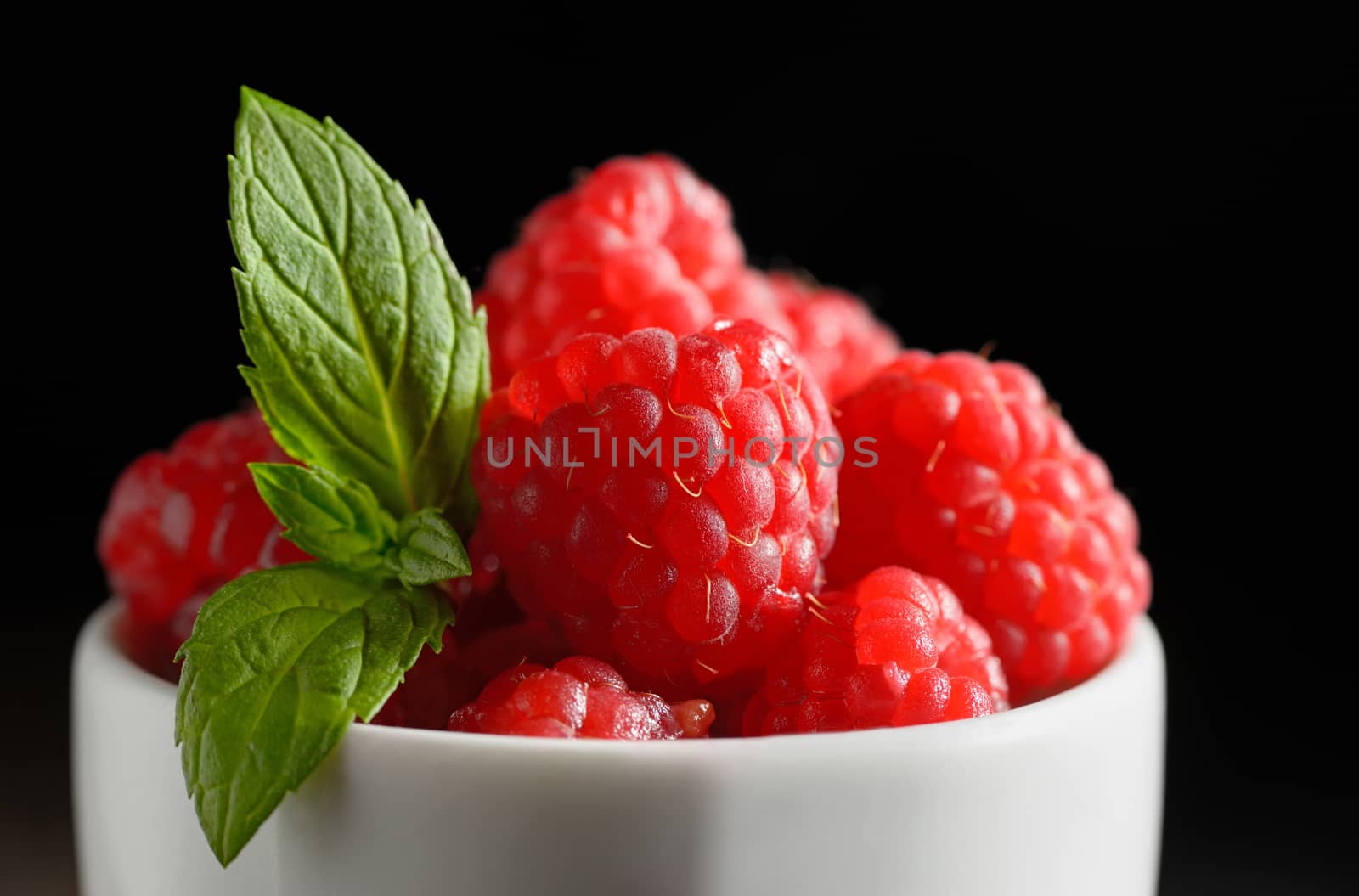 Wild raspberry  in ceramic bowl and mint leaves