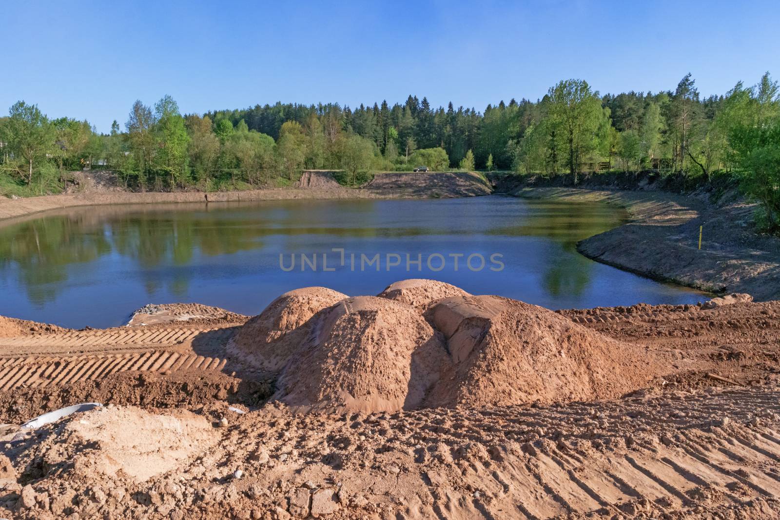 Preparation of the river bank near village for protection against a flood.Cumulative lake for drainage water.