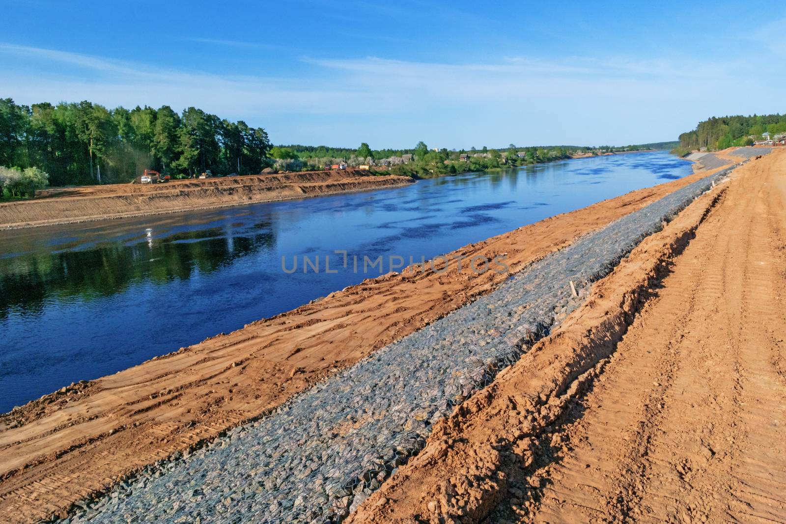 Preparation of the river bank near village for protection against a flood.