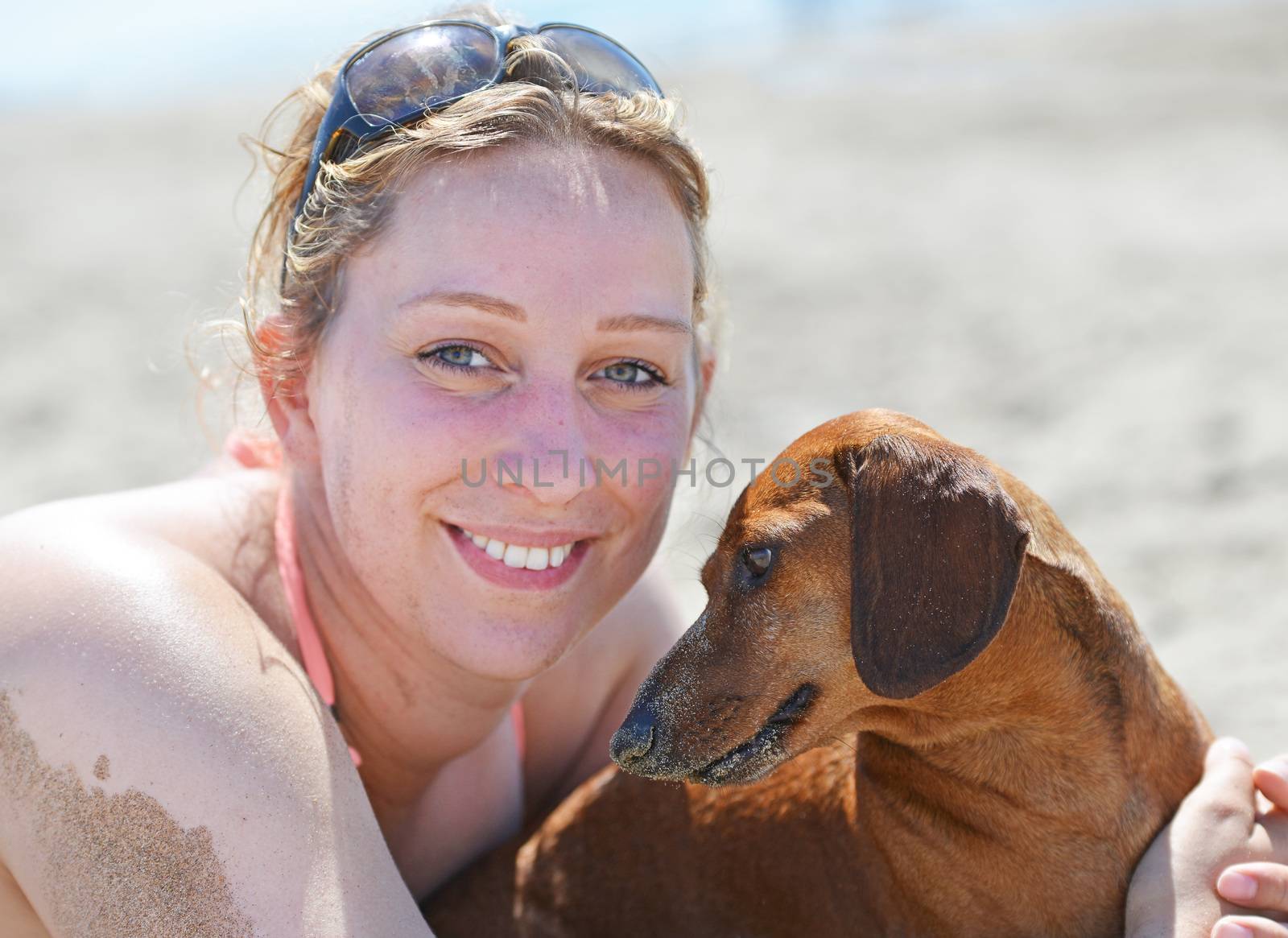 woman and dog on the beach by cynoclub