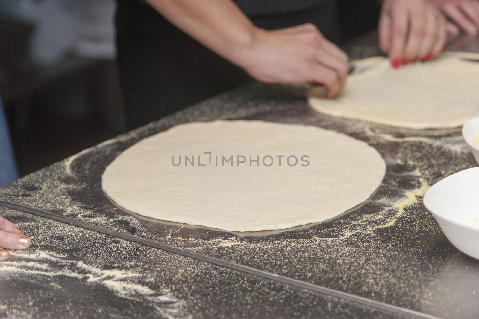 Woman chef with raw dough. Young female in uniform preparing bread dough on table.