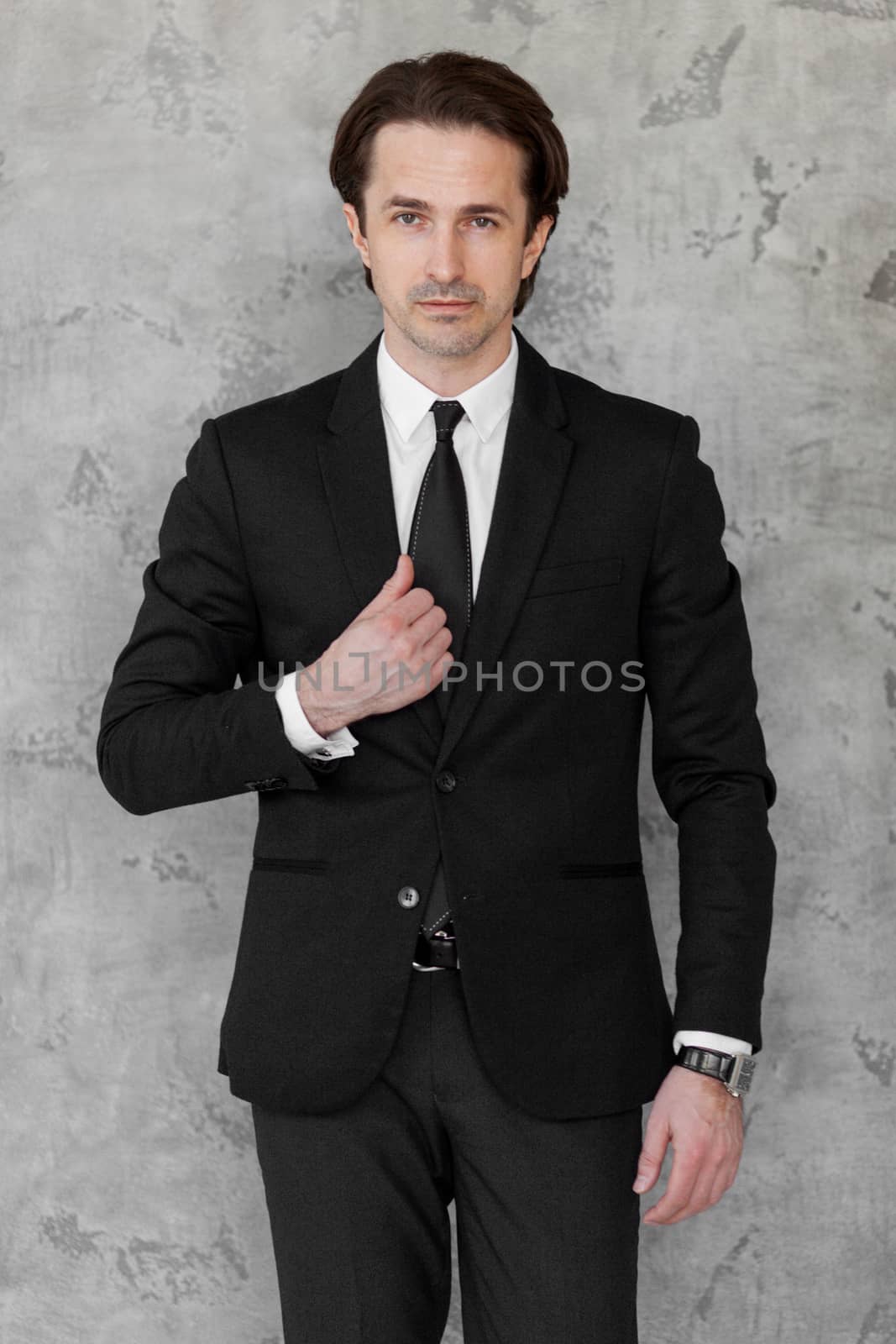 Portrait of businessman posing against a concrete wall