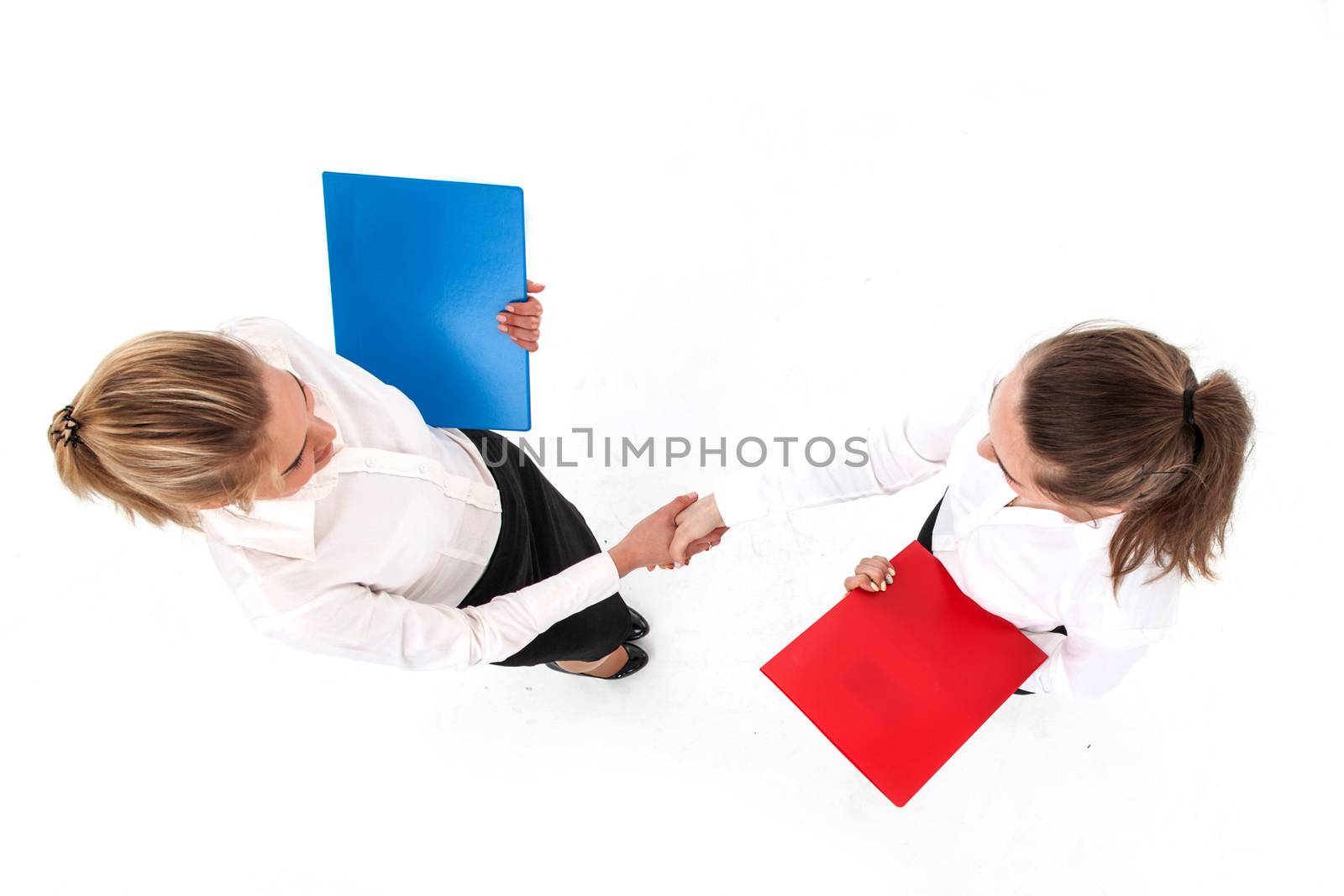 Top view of two business women shaking hands isolated on white background