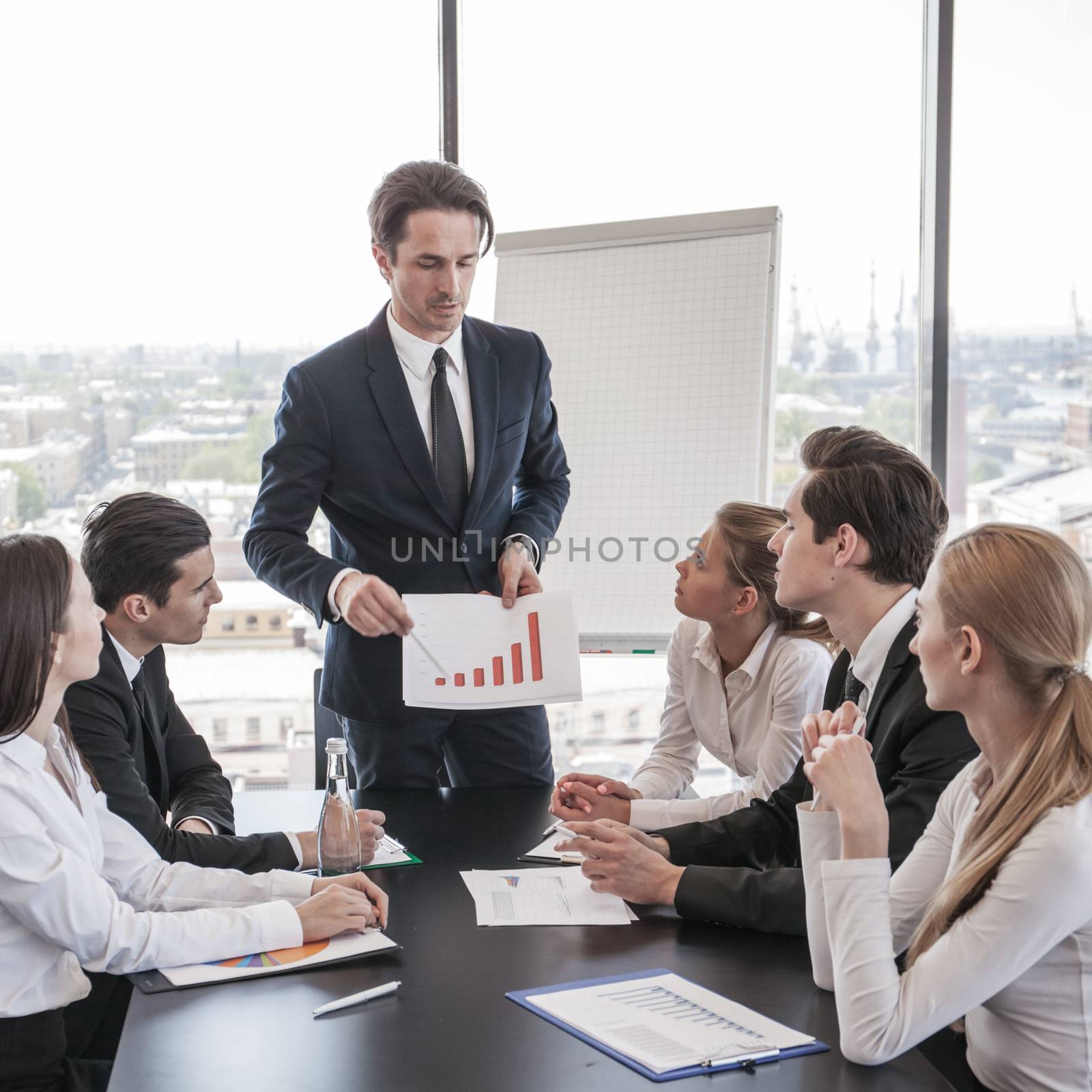 Business people discussing the charts and graphs showing the results of their successful teamwork