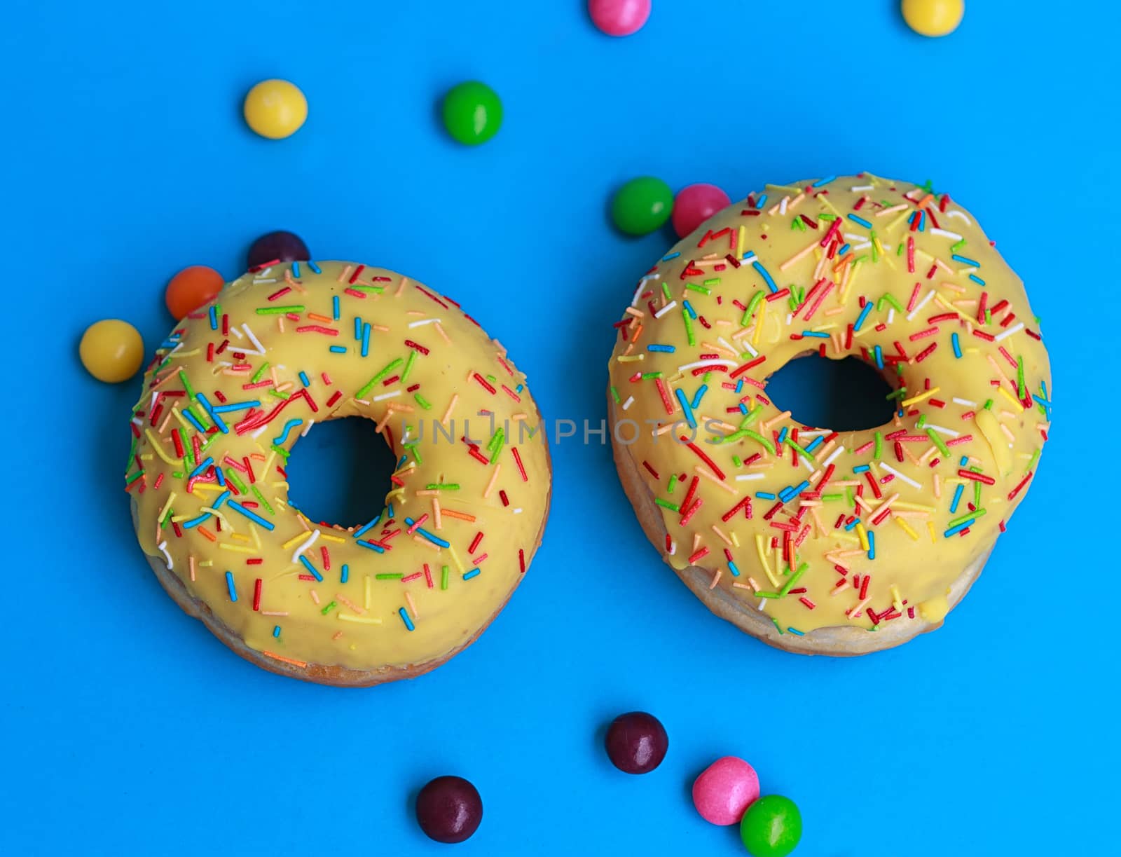 top view of two donuts on blue background