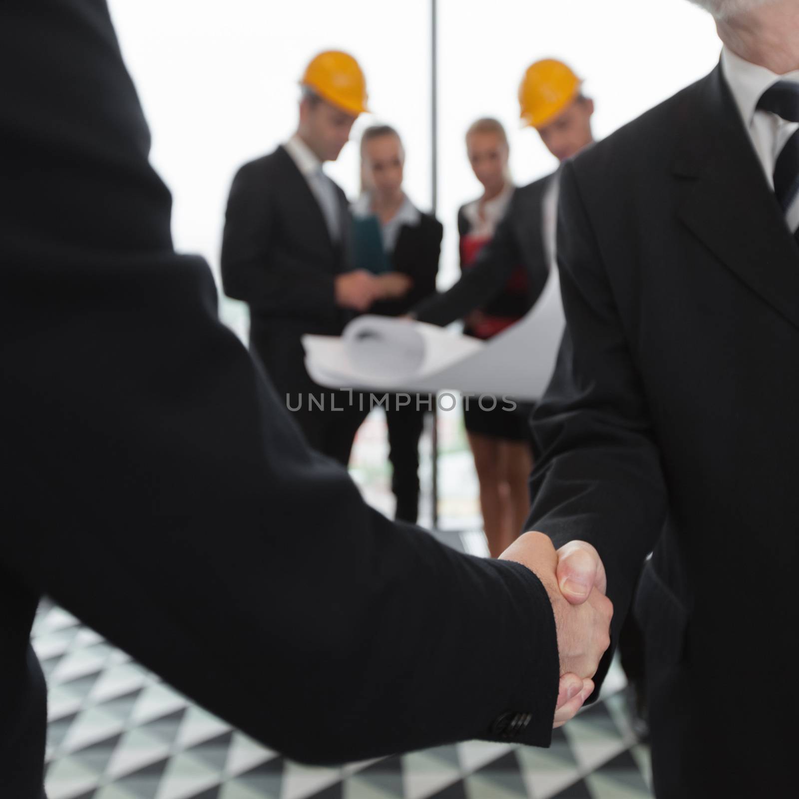 Handshake of architect and investor, business team with blueprint on background