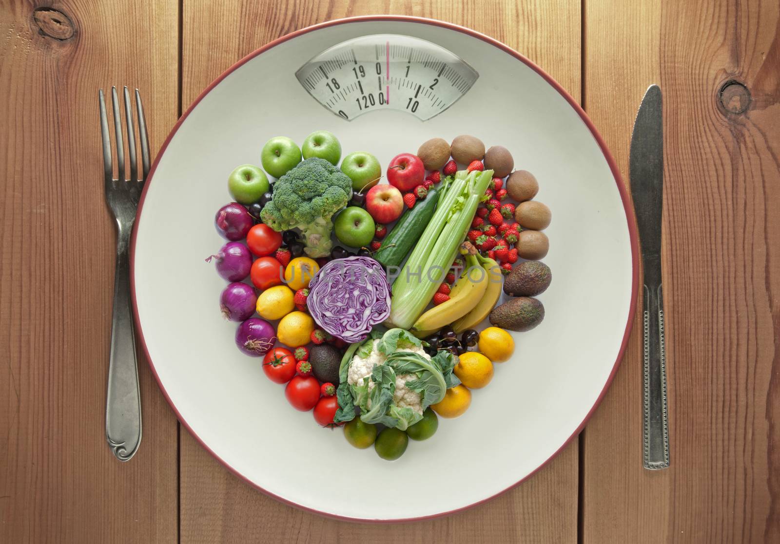 Plate with weighing scales packed with fruits and vegtables in a heart shape