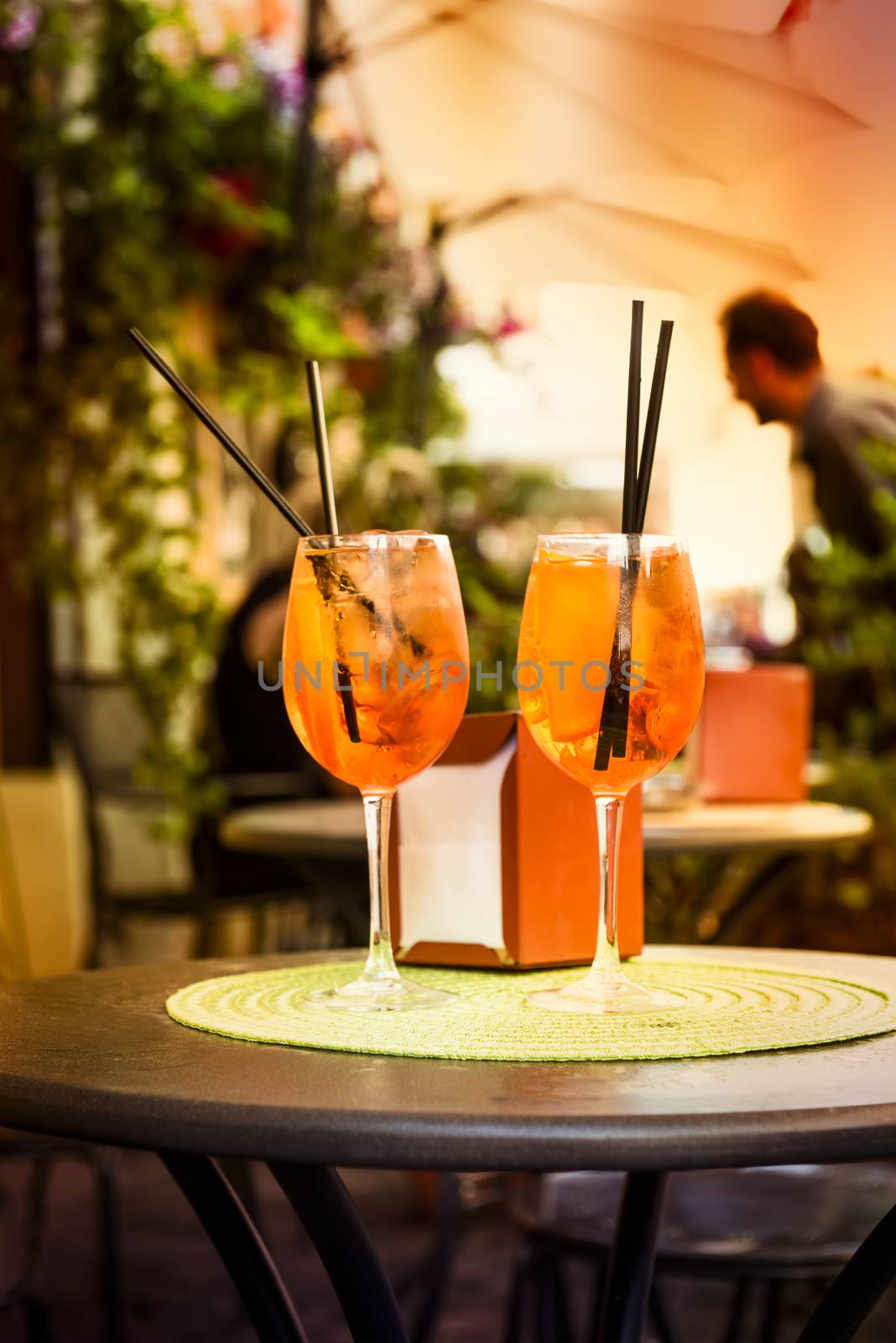 Aperol Spritz Cocktail. Alcoholic beverage based on table with ice cubes and oranges.
