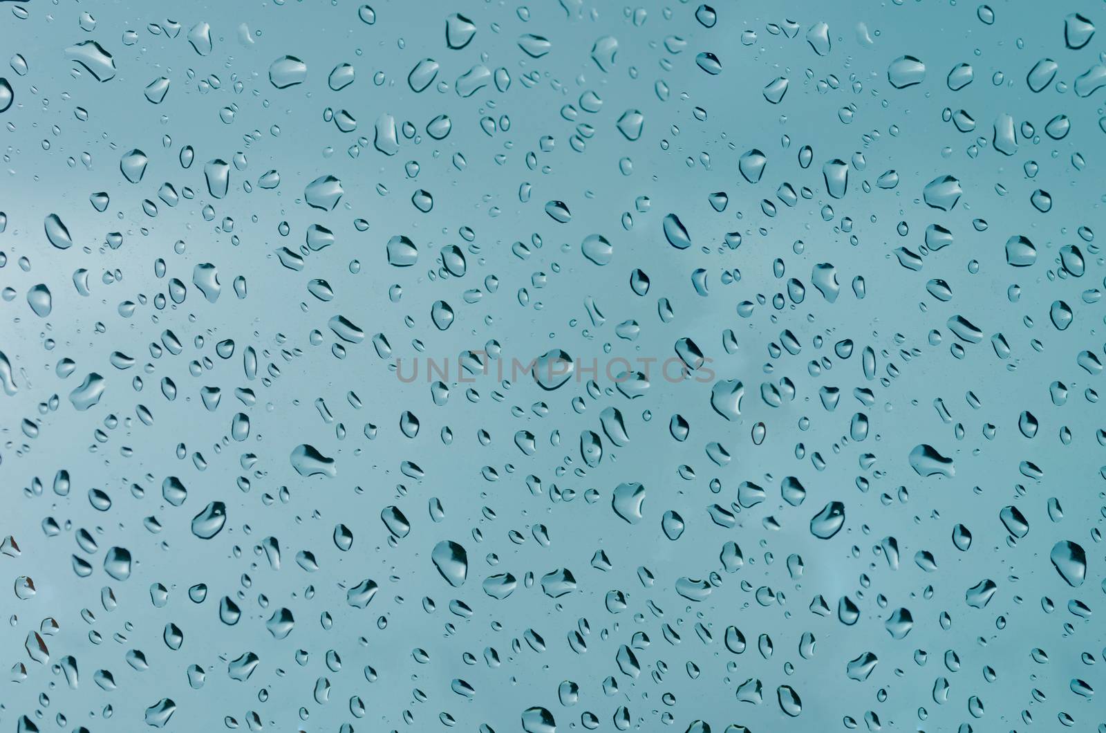 Water droplets on the glass with a colored background. Drops of water.