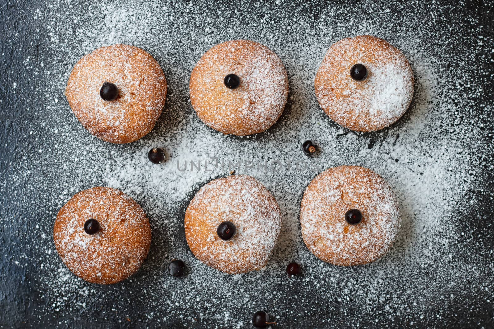 Muffins with black currant sprinkled with powdered sugar.