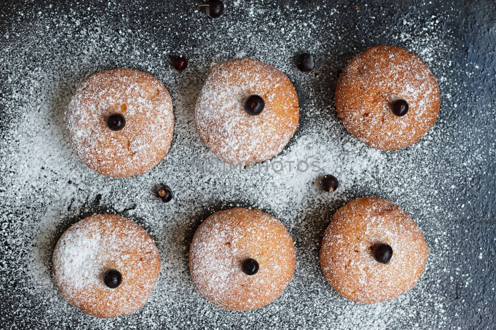 Muffins with black currant sprinkled with powdered sugar.