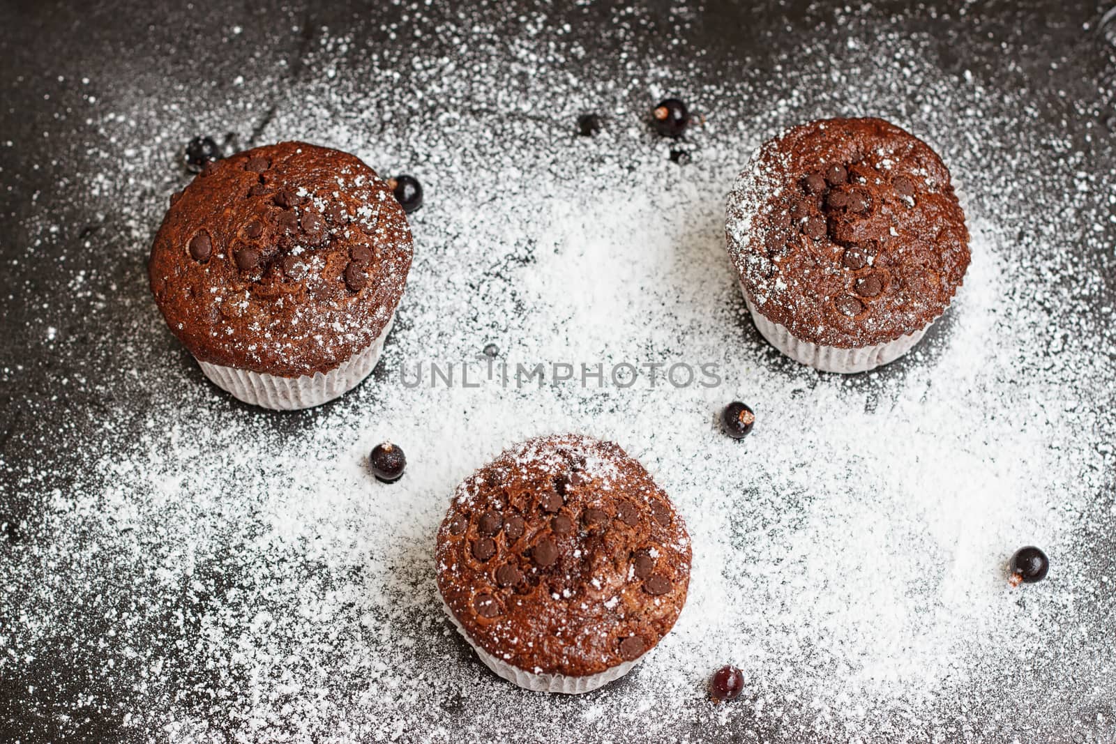 Chocolate cake on a black table with powdered sugar