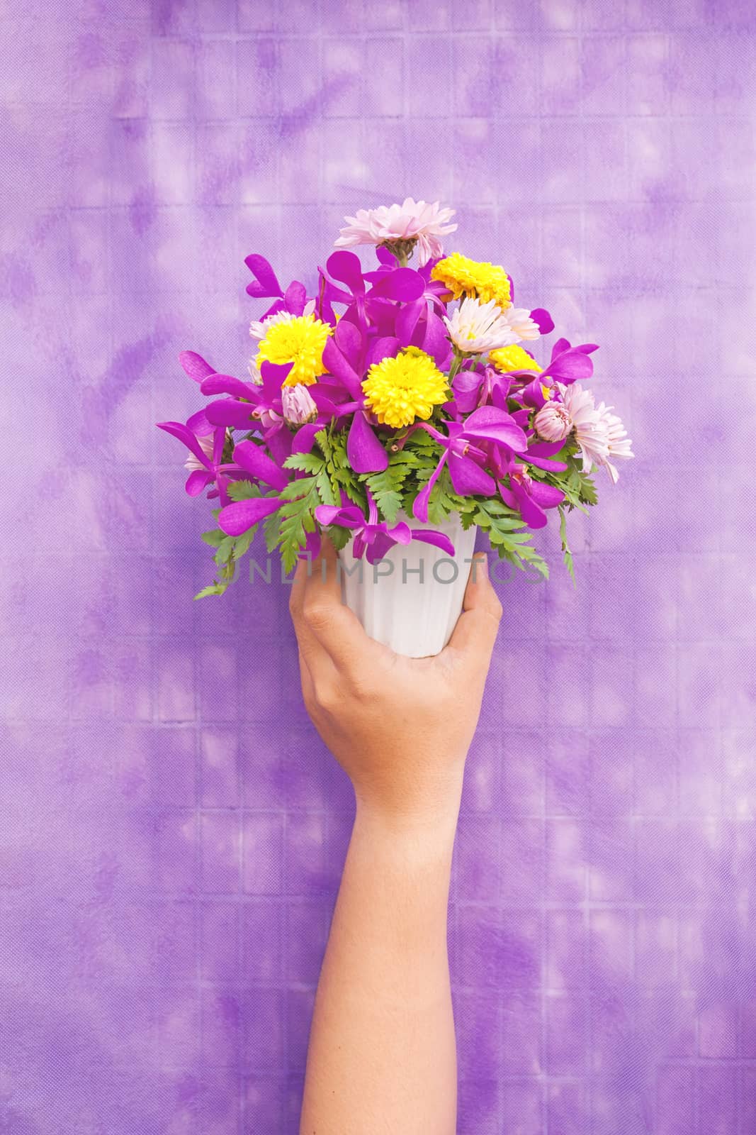 Hand holding bouquet of chrysanthemum and orchid flowers isolate by nopparats