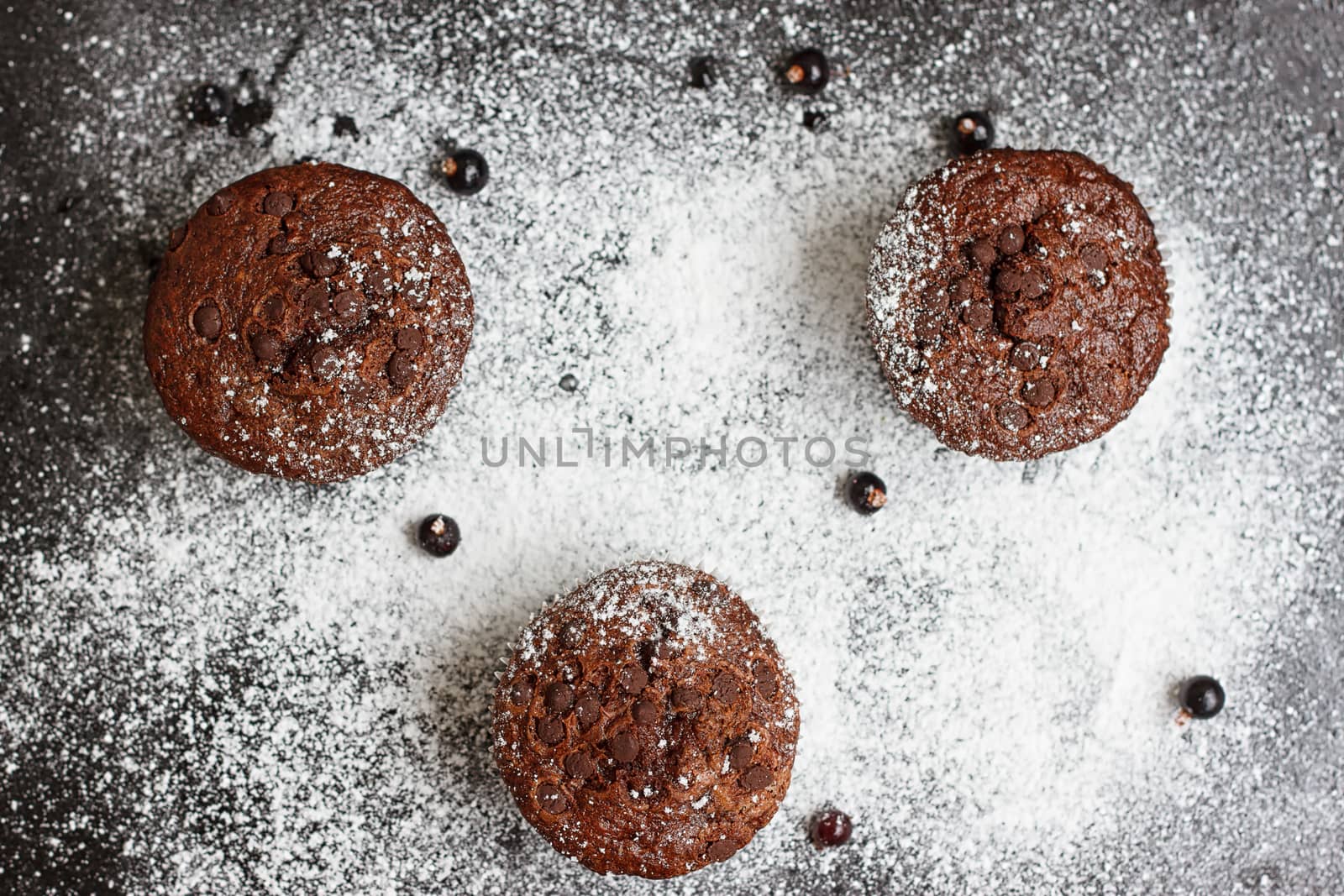 Chocolate cake on a black table with powdered sugar